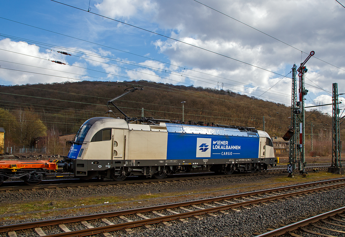 Die 1216 954 (91 81 1216 954-8 A-WLC) der WLC - Wiener Lokalbahnen Cargo GmbH (Wien), fhrt am 26.03.2021 mit einem Leerzug, neuer 4-achsiger Drehgestell - 40‘ Containertragwagen der Gattung Sgmmnss 738 der WASCOSA AG Z, durch Dillenburg in Richtung Gieen.

Die Taurus III bzw. Siemens ES 64 U4-C (Variante C fr sterreich, Deutschland, Tschechien und die Slowakei) wurde 2010 unter der Fabriknummer 21415 von Siemens gebaut und an die WLC geliefert.
