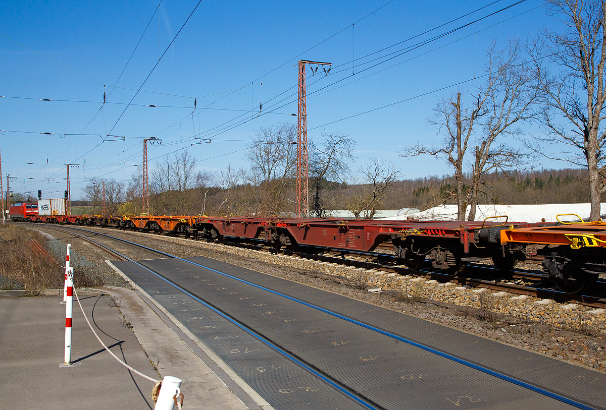 Die 152 124-4 (91 80 6152 124-4 D-DB) der DB Cargo AG erreicht am 30.03.2021 mit einem Containerzug Rudersdorf (Kr. Siegen). Bevor es in Richtung Siegen weitergeht, hat sie hier erst mal Hp 0 und muss den Gegenverkehr abwarten. Ein Gleis war wohl unterbrochen.

Hier im Vordergrund der Sechsachsige Gelenkwagen (Containertragwageneinheit 80´), für den Transport von Großcontainern und Wechselbehältern, 31 80 4850 183-3 D-DB der Gattung Sggrs 716 der DB Cargo AG.

Bei diesem Wagen handelt es sich um einen ursprünglichen 104-Fuß-Wagen der Bauart Sggmrs 715, welcher ursprünglich für kontinentale Wechselbrückenverkehre beschafft wurde. Aufgrund Veränderung der Ladebehälterstruktur im Containerverkehr, wurden 96 dieser Wagen 2017, durch den rumänischen Güterwagenhersteller Astra Rail Industries (seit 2012 zu Greenbrier), in diese Wagen der Bauart Sggrs 716 umgebaut. Der Umbau umfasste hauptsächlich die Kürzung des Wagens von 104 auf 80 Fuß, die Erhöhung der Aufstandshöhe, die Umkonstruktion der seitlichen Abstützung im Bereich der Gelenke sowie den Bremsumbau von Grauguss- (GG) auf innovative lärmarme Kunststoff-Bremssohlen (Cosid 810).

TECHNISCHE DATEN:
Spurweite: 1.435 mm
Länge über Puffer: 26.780 mm
Achsabstand in den Drehgestellen: 1.800 mm
Ladelänge: 2 x 12.250 mm
Höhe der Ladeebene über S.O.: 
Eigengewicht: 28.200 kg
Max. Zuladung bei Lastgrenze S: 104 t (ab Streckenklasse D) 
Max. Geschwindigkeit: 100 km/h (leer 120 km/h)
Kleinster befahrbarer Gleisbogen: R 75 m 
Bremse: 2 x KE-GP-A (K)
Bremssohle: Cosid 810
Feststellbremse: Nein
Verwendungsfähigkeit: RIV