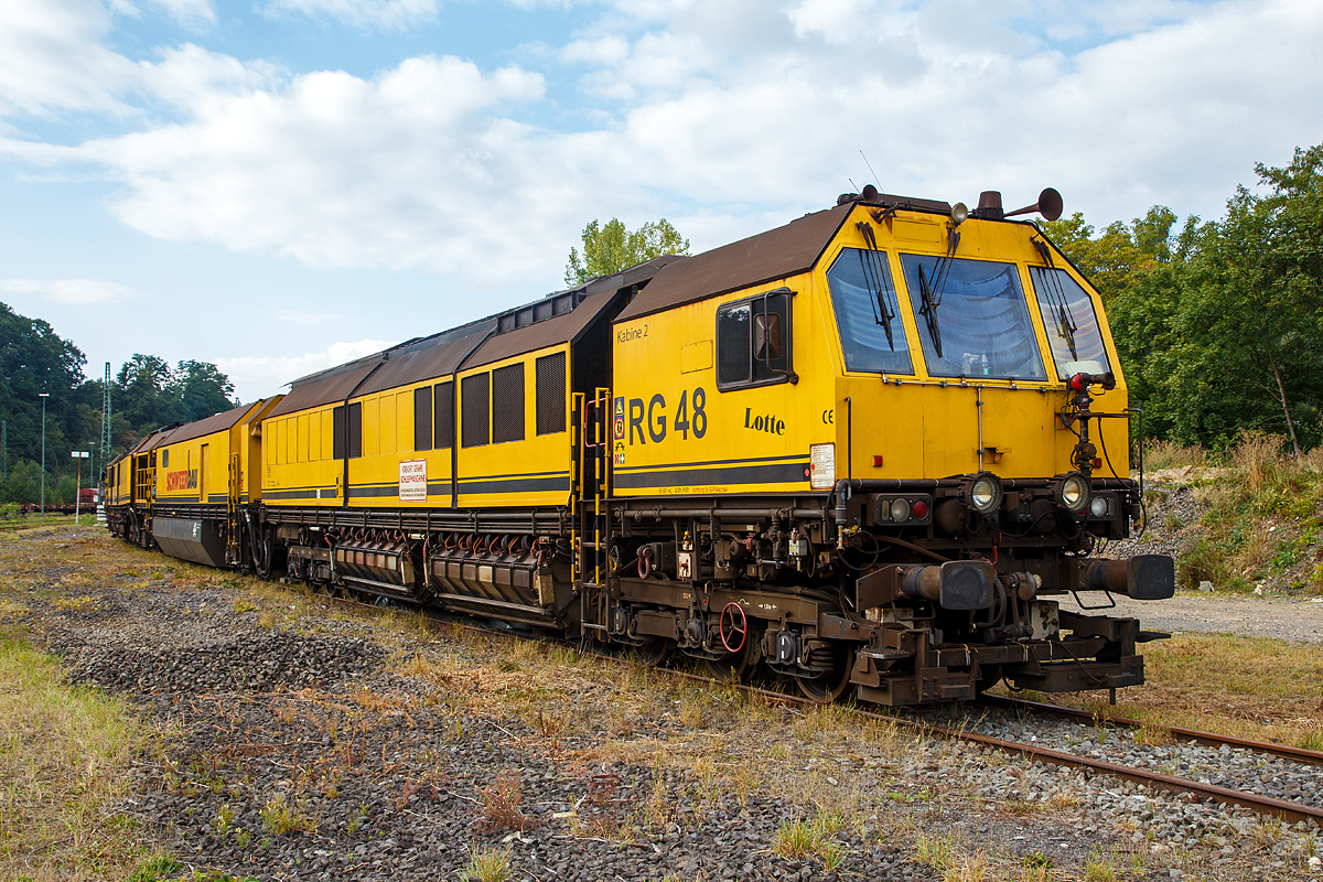 
Die „Lotte“ bzw. die LORAM Schienenschleifmaschine RG 48, Schweres Nebenfahrzeug Nr. 97 33 08 501 17-8, der Schweerbau steht am 18.09.2016 in Betzdorf/Sieg, wo die Tagschicht Wartungsarbeiten durchführt.

Die Schienenschleifmaschine wurde 2002 von LORAM Maintenance of Way, Inc. aus Hamel  / Minnesota (USA) unter der Fabriknummer  LMW001 für die Schweerbau gebaut. Die LORAM Type / Modell Bezeichnung  lautet RG148.

Die Schienenschleifmaschine RG 48 besteht aus drei Wagenteilen, zwei Schleifwagen (1+2) und eine Arbeitswagen dazwischen, die Maschine ist aber eine untrennbare Einheit. Die Schleifwagen ruhen jeweils auf zwei dreiachsigen  Drehgestellen, der Arbeitswagen auf zwei zweiachsigen Drehgestellen.

Die Schleifwagen haben insgesamt 48 Schleifmodule (24 pro Wagen), die elektrisch verstellt werden können, der Anpressdruck geschieht hydraulisch. Die Schleifmotoren  haben eine Leistung von jeweils 22,4 kW. Unter dem Arbeitswagen befindet sich ein Wassertank, mit einem Fassungsvermögen von 25.000 Liter, für Kühl- und Löschwasser. Die Maschinen kann in beide Richtungen arbeiten. Der kleinste bearbeitbare Bogenradius beträgt 180 m. Die Arbeitsgeschwindigkeit ist zwischen 2 und 15 km/h stufenlos einstellbar und abhängig vom Materialabtrag, vorzugweise wir zwischen 8 und 12 km/h gearbeitet. Bei einer Schleifgeschwindigkeit von 8 km/h können 0,25 mm Material angetragen werden. Für das Schleifen des gesamten Schienenkopfes beträgt die Stundenleistung zwischen 700 und 1400 m Gleis.

Die Schienen sind gehören zum wertvollsten Kapital der meisten Eisenbahnen. Die Schnittstelle von Rad und Schiene ist ein anspruchsvolles Thema, vor allem wegen der Kosten zu spät beseitigten Mängel. Typische Probleme auf allen angetroffen Eisenbahnen gehören Schälstellen, Abplatzungen, Seitenverschleiß, getaucht Schweißnähte, Riffen und Ermüdungen, sowie einzigartigen Herausforderungen der Lärmminderung und Fahrqualität.

Das Schienenschleifen gilt als die effektivste Wartung der Praxis, um die Auswirkungen von dem Verscheiß an der Schiene wiederherzustellen.
Zu der Investitionsrendite einer gut gewarteten (frühzeitig geschliffenen) Schiene gehören:
Ein längeres Schienen Leben;
Energie-  Kraftstoffersparnis;
Reduzierter Verschleiß an dem Rollmaterial;
Höhere Achslasten und Zuggeschwindigkeiten und
Verbesserte Fahreigenschaften und Komfort für die Passagiere.

Technische Daten:
Spurweite: 1.435 mm
Anzahl der Achsen: 16 (in 6 Drehgestellen)
Länge über Puffer: 62 325 mm (3 x 20.800 mm)
Drehzapfenabstände: 13.100 mm
Achsabstände in den Drehgestellen der Schleifwagen : 1.500 mm 
Achsabstände in den Drehgestellen vom Arbeitswagen : 1.800 mm
Raddurchmesser: 920 mm
Eigengewicht: 281.500 kg
Achslast: 20,5 t
Zul. Anhängelast: 40 t
Zur Mitfahrt zugel. Personen: 8
Motorleistung: 2x 1.007 KW 
Höchstgeschwindigkeit: 100 km/h
Kleinster befahrbarer Gleisbogen: R 100 m
Zugelassen für Streckenklasse: CE/CM4 und höher
