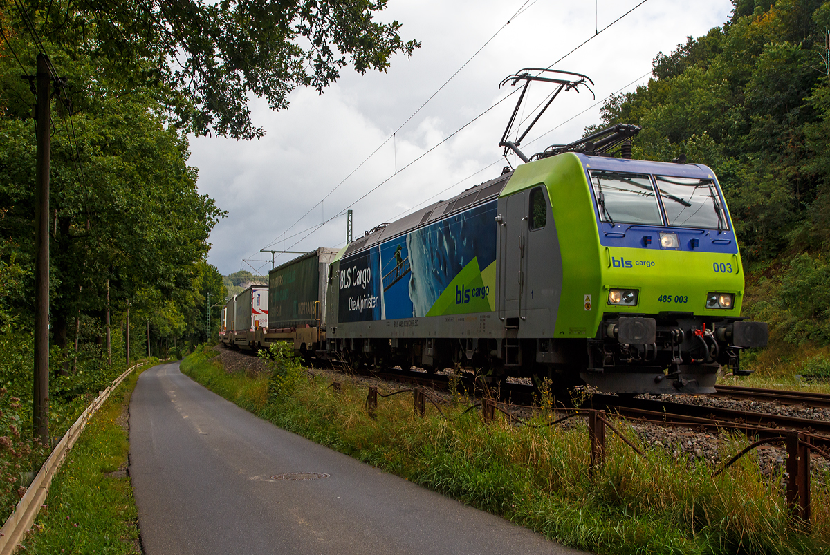 Die BLS Cargo 003 - Re 485 003-8  (91 85 4485 003-8 CH-BLSC) fährt am 26.08.2021 mit einem KLV-Zug bei Wissen (Sieg) über die Siegstrecke (KBS 460) in Richtung Köln.

Die TRAXX F140 AC1 wurde 2003 von  Bombardier in Kassel unter der Fabriknummer 33548 gebaut und an die BLS Cargo geliefert. Die Loks sind nur für die Schweiz und Deutschland zugelassen.

Die BLS Cargo AG bestellte 2002 die elektrischen Zweifrequenz-Güterloks des Typs Re 485, mit der Option über weitere 10 Stück. Die Lok sollen vor allem grenzüberschreitend im Verkehr mit Deutschland eingesetzt werden. 

Die Re 485 (TRAXX F140 AC1) sind 85 Tonnen schwer und 140 km/h schnell. Mit der installierten Leistung von 5,6 MW ist sie geeignet für den Transport schwerer Güterzüge über die Lötschberg—Simplon-Bergstrecke ebenso wie durch den Lötschberg-Basistunnel. Sie verfügt über je zwei Stromabnehmer für Deutschland und für die Schweiz und ist mit Zugsicherungssystemen beider Länder ausgerüstet.

Zusammen mit den technisch gleich ausgerüsteten DB-Cargo-Maschinen der Baureihe 185 sollen künftig - im Sinne der Kooperation der beiden Güterverkehrsunternehmen - Abläufe beschleunigt und Synergien erzielt werden.

TECHNISCHE DATEN:
Spurweite:  1.435 mm (Normalspur)
Achsformel:  Bo’Bo’
Länge über Puffer:  18.900 mm
Höhe:  4.385 mm
Breite:  2.978 mm
Drehzapfenabstand:  10.400 mm
Achsabstand im Drehgestell: 2.600 mm
Dienstmasse:  85 t
Höchstgeschwindigkeit:  140 km/h
Dauerleistung:  5.600 kW
Dauerzugkraft:  300 kN
Treibraddurchmesser:  1.250 mm
Stromsysteme:  15 kV 16,7 Hz (und 25 kV 50 Hz) Wechselstrom  
Antrieb:  Tatzlager