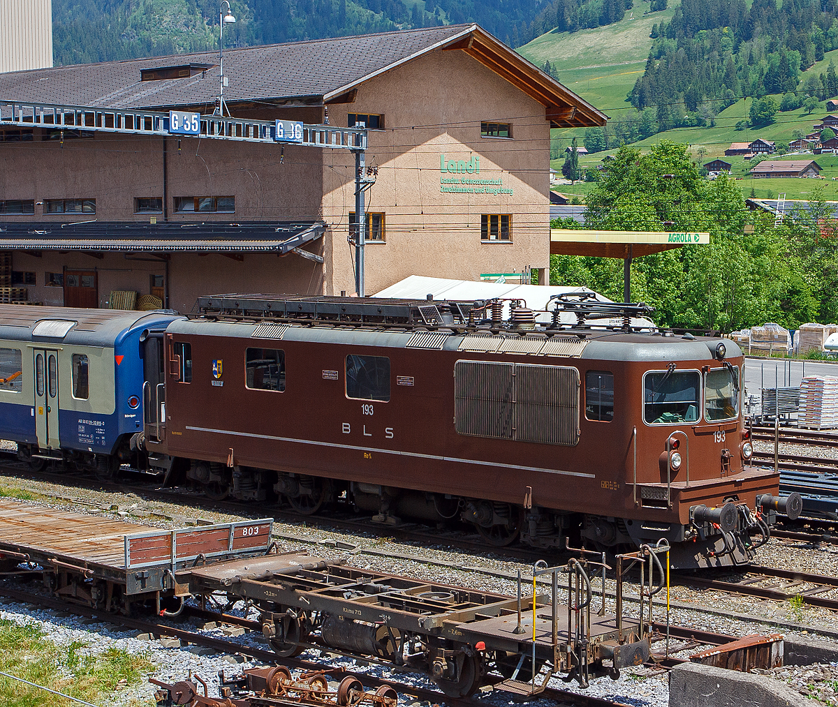 Die BLS Re 4/4 – 193 „Steg“ (Re 425 193) ist am 28.05.2012 beim Bahnhof Zweisimmen abgestellt, aufgenommen aus einfahrendem Goldenpass Zug.

Die Lok wurde 1983 von der Schweizerische Lokomotiv- und Maschinenfabrik (SLM) in Winterthur unter der Fabriknummer 5225 gebaut, die elektrische Ausrüstung ist von BBC. 

Die BLS hat mit der Eröffnung der Strecke Spiez - Frutigen den elektrischen Betrieb mit 15 kV / 16 2/3 Hz im Jahre 1910 eingeführt. Lange war der Pioniergeist der BLS wegweisend für die Triebfahrzeugentwicklung in der Schweiz. Die Lokomotiven aus der Anfangszeit der Elektrifizierung waren den Forderungen der modernen Zugförderung nicht mehr gewachsen. Die BLS begann zusammen mit SLM und BBC Anfang der sechziger Jahre eine moderne Universallokomotive (Ae 4/4 II) zu entwickeln. 

Die BLS Re 4/4 (ursprünglich Ae 4/4 II) wurde von 1964 bis 1983 als Universallokomotive mit guter Bergleistung von der Bern-Lötschberg-Simplon-Bahn (BLS) beschafft, um die Züge mit höheren Geschwindigkeiten befördern zu können und um die Lokomotiven der Gründungsjahre abzulösen. Mit 35 gebauten Lokomotiven wurde die Re 4/4 die größte Lokomotivserie der BLS-Gruppe.

Aufgrund der sehr erfolgreichen Konstruktion der Ae 4/4 der BLS, der ersten laufachslosen Hochleistungslokomotive der Welt, leiteten die BLS und SLM die Neuentwicklung von dieser Reihe ab. Das ist auch an der Kastenform eindeutig zu erkennen, die Anordnung der Einstiege an der Lokfront wurde von der Ae 4/4 übernommen. Das Fahrgestell ist ähnlich demjenigen der SBB Re 4/4 II. Doch da hören die Gemeinsamkeiten zu dieser auch sehr erfolgreichen Baureihe auf. So wird die Kraft mit einer anders konstruierten Tiefzuganlenkung und Seilzug auf die Schienen gebracht. Statt Sandereinrichtungen besitzt die Lok Schienendüsen. Bei vielen Versuchen und Vergleichen mit z. T. ausländischen Lokomotiven stellt die Re 4/4 noch heute ihre enorme Leistungsfähigkeit am Berg unter Beweis. Einen 630-Tonnen-Zug kann die Lok auf einer 26-‰-Steigung mit 80 km/h befördern. Die Stundenzugkraft beträgt 226 kN bei 77,5 km/h. So wurde damals, aufgrund der mit der Thyristorsteuerung ausgerüsteten Re 4/4 161 absolvierten Vorführungs- und Probefahrten am Semmering, die ÖBB 1044 entwickelt.

Die Ansteuerung der Fahrmotoren erfolgt über den BBC-Trafo, Stufenschalter mit Luftmotor auf den Diodengleichrichter. Die elektrische Bremse, bis 600 A Bremsstrom, wirkt mithilfe der Dachwiderstände. Die Lokomotiven können in Vielfachsteuerung unter sich oder mit den BLS Re 465 verkehren. Ebenfalls möglich war einige Jahre lang die Vielfachsteuerung mit den inzwischen ausrangierten Ae 8/8 und Ae 4/4, nachdem diese Loktypen mit Vielfachsteuerung ausgerüstet worden waren. Bei den Re 4/4 war die Vielfachsteuerung ab 1967 eingebaut worden.

Die ersten fünf Maschinen waren bei Ablieferung nur für 125 km/h zugelassen und wurden dementsprechend bis 1969 als Ae 4/4 II 261–265 bezeichnet. Die Änderung der Serienbezeichnung erfolgte nachdem die Zulassung für die Geschwindigkeitsreihe „R“ erteilt war. Dazu mussten Achsseitenfederungen eingebaut werden, um die Schienenbeanspruchung zu vermindern. Die Gummisekundärfederung der ersten fünf Lokomotiven bewährte sich nicht und wurde durch Schraubenfedern mit einem parallelen Stoßdämpfer ersetzt. Seither tragen die Lokomotiven die Bezeichnung Re 4/4.

Ab der Lokomotive Re 4/4 174 wurde der Kasten um 370 mm verlängert, um später die automatische Kupplung einbauen zu können. Die Re 4/4 161 bis 189 sind mit Scherenstromabnehmern ausgerüstet, während die Re 4/4 190 bis 195 mit Einholstromabnehmern geliefert wurden.

TECHNISCHE DATEN der Re 4/4 174 bis 195:
Spurweite:  1.435 mm (Normalspur)
Achsformel:  Bo’Bo’
Länge über Puffer:  15.470 (15.100 mm Lok 161 bis 173)
Drehzapfenabstand: 7.900 mm
Achsabstand im Drehgestell: 2.800 mm
Treibraddurchmesser:  1.250 mm
Höhe:  4.500 mm
Breite:  2.950 mm
Dienstgewicht:  80 t
Höchstgeschwindigkeit: 140 km/h
Dauerleistung:  4.980 kW (6.770 PS)
Anfahrzugkraft:  320 kN
Dauerzugkraft: 236 kN
Anzahl Fahrmotoren: 4
Übersetzungsverhältnis: 1 : 3,346
Stromsystem:  Wechselstrom 15 kV 16,7 Hz
