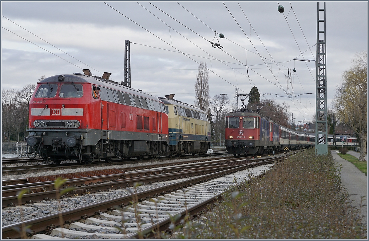 Die DB V 218 419-0 und die Westfrankenbahn 218 460-4 warten auf dem Seedamm in Lindau den nun von Zürich kommenden EC, welcher von der SBB RE 421 371-6 angeführt wird. Die zweite Re 421 läuft Umlaufbedingt mit.

16. März 2019