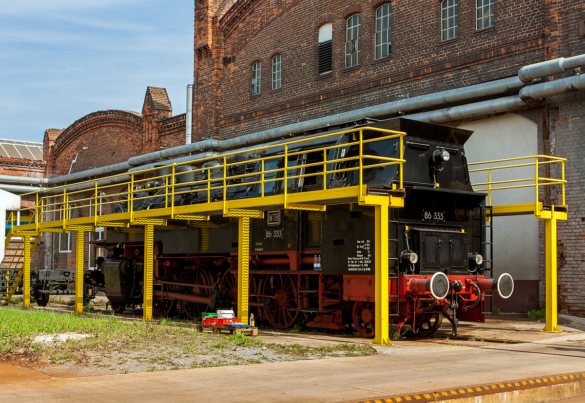 Die Einheits-Güterzugtenderlokomotive  86 333, ex DR 86 1333-3, ex DR 086 333-2, (damals 2013) der WTB - Wutachtalbahn e.V. steht am 24.08.2013 im Dampflokwerk Meiningen (DLW).

Die 1D1-Tenderlokomotive (vierfach gekuppelte Tenderlokomotive) wurde 1939 von der WLF - Wiener Lokomotivfabrik Floridsdorf unter der Fabriknummer  321gebaut. Seit 2007 besitzt sie einen, vom DLW - Dampflokwerk Meiningen 2006 unter der Fabriknummer 1536, gebauten Neubaukessel.

Nach dem Krieg blieb sie im Osten und kam zur DR - Deutsche Reichsbahn. Ihr wechselvoller Lebenslauf bei der Deutschen Reichsbahn führte die Lok durch zahlreiche Betriebswerke Mitteldeutschlands. Die längste Verweildauer hatte sie in den Betriebswerken Chemnitz und Glauchau. Im Jahr 1970 erfolgte die Umzeichnung in 86 1333-3, im Jahr 1992 wurde sie als 086 333-2 geführt. 

Weitere Lebenslauf und Eigentümer:
1993-1995  EVG - Eisenbahnverkehrsgesellschaft, Aalen  als 86 333 
1995-1997  BEM - Bayrisches Eisenbahnmuseum Nördlingen 
1997-2015 86 333 WTB - Wutachtalbahn e.V. , von 2007 bis 2013  als 90 80 0086 333-2 D-WTBB, von 2013 bis 2015 als 90 80 0086 333-2 D-DBFZI
2015 wurde die Lok an die PRESS, Eisenbahn-Bau- und Betriebsgesellschaft Pressnitztalbahn mbH verkauft und wird als 86 1333-3 (90 80 0086 333-2 D-PRESS) geführt.

Die Baureihe 86 wurde als Einheits-Güterzugtenderlokomotive von der Deutschen Reichsbahn entworfen. Sie war für den Einsatz auf den Nebenstrecken vorgesehen und wurde von fast allen für die Deutsche Reichsbahn tätigen Unternehmen geliefert. Die ersten Lieferungen (wie diese hier) waren noch mit Bissel-Laufachsen ausgerüstet, die Maschinen mit den Betriebsnummern 86 293-296 und ab der Nummer 86 336 erhielten aber dann Krauss-Helmholtz-Gestelle. Dadurch konnte die Höchstgeschwindigkeit von 70 auf 80 km/h heraufgesetzt werden, die Gesamtlänge wuchs auf 13.920 mm. Ab 1942 wurde sie in einer vereinfachten Form als Übergangskriegslokomotive (ÜK) gebaut. Im Zeitraum von 1928 bis 1943 wurden 775 Exemplare gebaut, von denen alle bis auf zwei Maschinen nach dem Zweiten Weltkrieg wieder aufgefunden wurden.

385 Maschinen verblieben auf dem Netz der Deutschen Bundesbahn in Westdeutschland, wovon 8 Lokomotiven wegen Kriegsschäden bis 1952 ausgemustert wurden. Die Deutsche Reichsbahn konnte nach Abgabe von 71 Loks an die Sowjetischen Eisenbahnen (SŽD) von dann noch vorhandenen 172 Exemplaren 164 in den Betriebsbestand aufnehmen.

TECHNISCHE DATEN (dieser Lok bzw. der ersten Serien):
Spurweite: 	1435 mm (Normalspur)
Achsformel: 1'D1'
Bauart: 1'D1' h2t
Gattung: Gt 46.15
Länge über Puffer: 13.820 mm
Höhe: 4.165 mm
Kleinster bef. Halbmesser: 	140 m
Leergewicht: 70,0 t
Dienstgewicht: 88,5 t
Achslast:15,6 t
Höchstgeschwindigkeit :70 km/h (vorwärts und rückwärts)  
Indizierte Leistung: 1.031 PSi
Kuppelraddurchmesser: 1.400 mm
Laufraddurchmesser (vorn / hinten): 850 mm
Steuerungsart: Heusinger mit Kuhnscher Schleife
Zylinderanzahl: 	2
Zylinderdurchmesser: 	570 mm
Kolbenhub: 660 mm
Kessellänge: 4.500 mm
Kesselüberdruck: 14 kp/cm² (14 bar)
Wasservorrat: 9,0 m³
Kohlevorrat: 4,0 t
