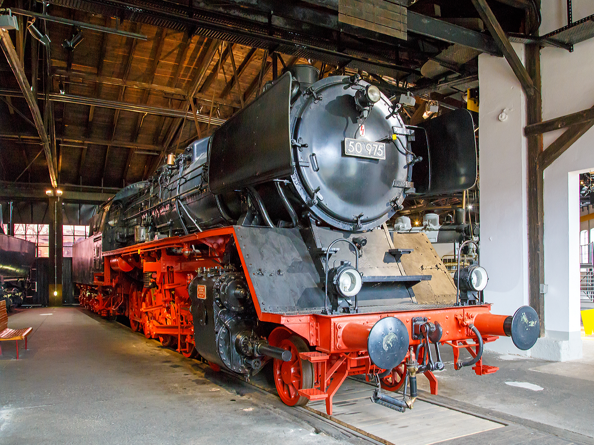 Die Güterzug-Dampflokomotive 50 975, ex DB 050 975-2, am 26.03.2016 im DDM - Deutsches Dampflokomotivmuseum in Neuenmarkt-Wirsberg.

Die Lok wurde 1941 von der Friedrich Krupp GmbH in Essen unter der Fabriknummer 2340 gebaut und als DRB 50 975 an die Deutsche Reichsbahn geliefert. Seit 15.Februar 1961 hat die Lok den Kessel der 50 2830, dieser wurde 1942 von der Krauss-Maffei AG (München-Allach) unter der Fabriknummer 16347 gebaut. Der Tender ist der originale von Krupp (Fabriknummer 2340). 

Als einzige 50er-Lok der Deutschen Bundesbahn erhielt sie für die Versuchseinsätze beim Bundesbahn-Zentralamt Minden eine Riggenbach-Gegendruckbremse, dort war sie auch vom 01.06.1951 bis zum 01.03.1963 stationiert.

Zum 15.02.1975 erfolgte die z-Stellung und am 16.05.1975 die Ausmusterung (Bw Weiden) bei der Deutschen Bundesbahn. Bis dahin hatte sie eine Laufleistung von 1,6 Mio. km. Im Jahr 1976 kam sie dann zum DDM.


Die Güterzuglokomotiven der Baureihe 50 zählen zu den bewährtesten Konstruktionen der Deutschen Reichsbahn. Am Ende der Dampflokzeit sind sie zur Universalgattung geworden, die Dank der niedrigen Achslast auch auf Nebenbahnen eingesetzt werden konnten. Bis 1943 wurden 3164 Maschinen der Baureihe 50 von nahezu allen europäischen Lokomotivfabriken gebaut.


Bei der DB wurden nach dem Zweiten Weltkrieg 2159 einsatzfähige Lokomotiven registriert, bei 735 Lokomotiven rüstete die DB den Tender mit einer Zugführerkabine aus. Eine kleinere Anzahl von Lokomotiven wurde mit einem Mischvorwärmer bestückt und insgesamt 31 Lokomotiven wurden mit Franco-Crosti-Anlagen ausgerüstet und anschließend als Reihe 50.40 geführt.


Technische Daten:
Gebaute Stückzahl: 3.164
Spurweite: 1.435 mm (Normalspur)
Bauart:  1'E h2
Gattung: G 56.15
Länge über Puffer.  22.940 mm
Höhe:  4.500 mm
Fester Radstand  3.300 mm
Gesamtradstand  9.200 mm
Dienstgewicht:  86,9 t (ohne Tender)
Achslast: 15,2 t
Höchstgeschwindigkeit  80 km/h (vorwärts und rückwärts)
Leistung: 1.625 PS
Treib- und Kuppelraddurchmesser: 1.400 mm
Laufraddurchmesser:  850 mm
Steuerungsart  Heusinger mit Hängeeisen
Zylinderanzahl:  2
Zylinderdurchmesser:  600 mm
Kolbenhub: 660 mm
Kesselüberdruck:  16 bar
Anzahl der Heizrohre  113
Anzahl der Rauchrohre  35
Heizrohrlänge  5.200 mm
Rostfläche:  3,89 m2
Überhitzerfläche:  68,94 m2
Verdampfungsheizfläche:  177,83 m2
Tender:	2´2´ T 26
Wasservorrat:	26 m³	
Brennstoffvorrat: 8 t (Kohle)
