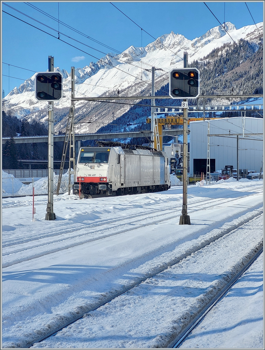 Die Railpool 186 497 wartet in Airolo bis ihr Zug mit Aushubmaterial beladen ist, um in dann nach Flelen zu bringen. Der Verladevorgang dauert etwa zwei Stunden. Das Bild entstand einem kurzen Ausgenblick,  als die Sonne auch diesen Teil des Bahnhofs erreichte.

25. Jan. 2025