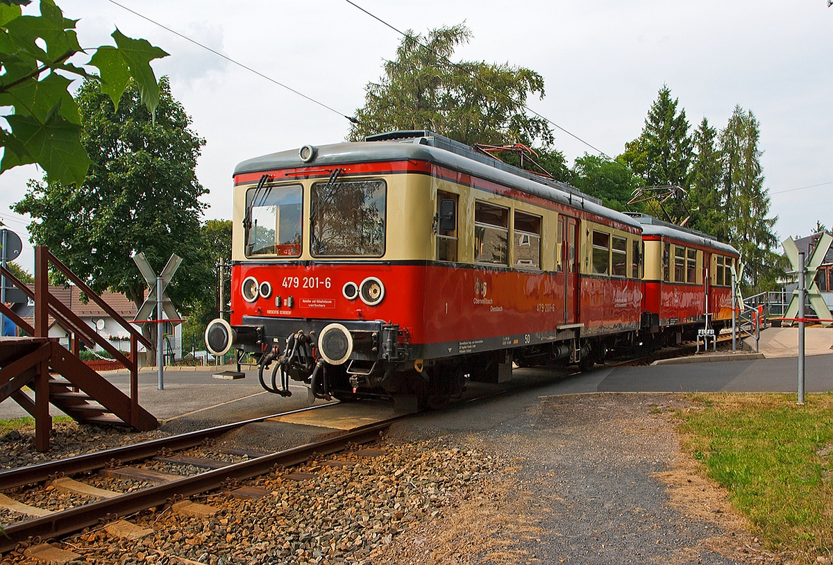 Die Triebwagen der Oberweibacher Bergbahn DB 479 201-6 und DB 479 203-2 sind am 24.08.2013 gerade vom Bergbahnhof Lichtenhain  nach Cursdorf losgefahren, diese Triebwagen fahren hier auf der Flachstrecke der KBS 563 zwischen Lichtenhain und Cursdorf. 

Es gibt insgesamt drei dieser Elektro-Triebwagen, es sind die einzigen ihrer Art und werden im Nummernsystem der Deutschen Bahn AG als Baureihe ET 479 bezeichnet. So gleich wie sie  aussehen, ist ihre Herkunft ganz und gar nicht. Jeder von ihnen hat seine eigene, faszinierende Geschichte, die geprgt ist von der stndigen Geldnot der Bergbahnbetreiber und  wirtschaftlichen Zwngen. So kam zu DDR- Zeiten die  Deutschen Reichsbahn als Betreiber in die Situation, unbedingt neue Fahrzeuge beschaffen zu mssen. Jedoch gab es nie eine Freigabe fr solch ein Vorhaben. Also umging man den  Neubau  und beauftragte  Umbauten . Das Reichsbahnausbesserungswerk (Raw) Berlin-Schneweide, das diese Triebwagen und Beiwagen betreute und fr die Instandsetzung der Berliner S-Bahn verantwortlich war, durfte keine Neubauten ausfhren, jedoch Umbauten (Rekonstruktionen) vornehmen. So entstanden nacheinander drei nahezu identische Fahrzeuge, die ganz  zufllig  den S-Bahn-Zgen der Baureihe 476/477 (ex. 276) hnlich sind und gleiche Front- und Seitenteile haben, sowie gleiche zweiflglige Schiebetren. 

Vorne DB 479 201-6, ex DRG ET 188 531, ex DR 279 201-8, dieser ist der einzige speziell fr die Flachstrecke gebaute Triebwagen, er entstand 1922/23 in der Gothaer Waggonfabrik und die Bergmann Elektrizittswerke in Berlin lieferten die Elektrik. Das Fahrzeug erhielt 1969 die EDV-Nummer DR 279 201-8. 1970 wurde er grundlegend umgebaut und mit einem neuen Wagenkasten ausgerstet, 1982 nochmal im Raw Schneweide umgebaut. Er wird seit 1991 unter der Nummer 479 201-6 gefhrt. 

Hinten der DB 479 203-2, ex Leipziger Straenbahn Nr. 939, ex DR 188 701, ex DR 279 203-4. Dieser Triebwagen wurde 1909 als Straenbahntriebwagen 209 dfr die Leipziger Elektrischen Straenbahn durch die Waggonfabrik P. Herbrand in Kln gebaut, die elektrische Ausstattung lieferte AEG in Berlin. Der Wagen wurde im Lauf seiner Betriebszeit viermal grundlegend umgebaut, so dass es nicht sicher ist, ob zuletzt berhaupt Teile des Ursprungsfahrzeuges vorhanden sind. 
1929/30 wurde er wie alle Triebwagen des Typs 16 in den Typ 27 mit geschlossenen Plattformen umgebaut, bis 1955 war er bei der Leipziger Straenbahn. Im  Raw Gotha wurde er dann 1955 fr den Einsatz auf der Flachstrecke angepasst und u.a. auf Regelspur mit Fernbahnradreifen umgespurt, mit Pufferbohlen und Puffern sowie einem seitlich versetzten Stromabnehmer versehen. Auerdem erhielt er wieder eine diesmal indirekte Druckluftbremse. Anschlieend erhielt er die Betriebsnummer ET 188 701. In dieser Form diente er vorwiegend als Reservefahrzeug. 1963 erfolgte der dritte Umbau, diesmal im Raw Berlin-Schneweide: Das Fahrzeug erhielt einen neuen, eckigen Wagenkasten mit abgeschrgten Enden in geschweiter Stahlausfhrung sowie rollengelagerte Radstze mit 800mm Laufkreisdurchmesser und einem Achsstand von 5000 Millimetern. Die elektrische Ausrstung und Steuerung wurde an den ET 188 531 angepasst. Mit der Einfhrung der EDV-Nummerierung 1969 erhielt er die Nummer 279 203-4. Der letzte Umbau erfolgte dann 1984 im im Raw Schneweide.  

Technische Daten fr ET 479 201 und 203:
Achsfolge:  Bo
Achsstand : 6.500 mm
Lnge ber Puffer:  11.600 mm
Raddurchmesser:  900 mm
Dienstgewicht:  19,5 t
Bremsgewicht:  15,5 t
Stromsystem:  600 V Gleichstrom
Antrtiebsleistung : 2 x 60 kW Gleichstrom-Reihenschlussmotoren
Hchstgeschwindigkeit:  50 km/h
Sitzpltze:  24
Stehpltze:  84
Bremsen: 2 Handbremsen, elektrische Widerstandsbremse, Druckluftbremse Bauart Knorr  KpBr , Bremsstellung  P 
Sicherheitsfahrschaltung  Bauart: Sifa 86

Damit die Wagen auf der Gterbhne nach Lichtenhain auf die Flachstrecke der Oberweibacher Bergbahn transportiert werden konnten, erhielten sie deshalb den relativ kurzen Achsstand von 6,5 m.