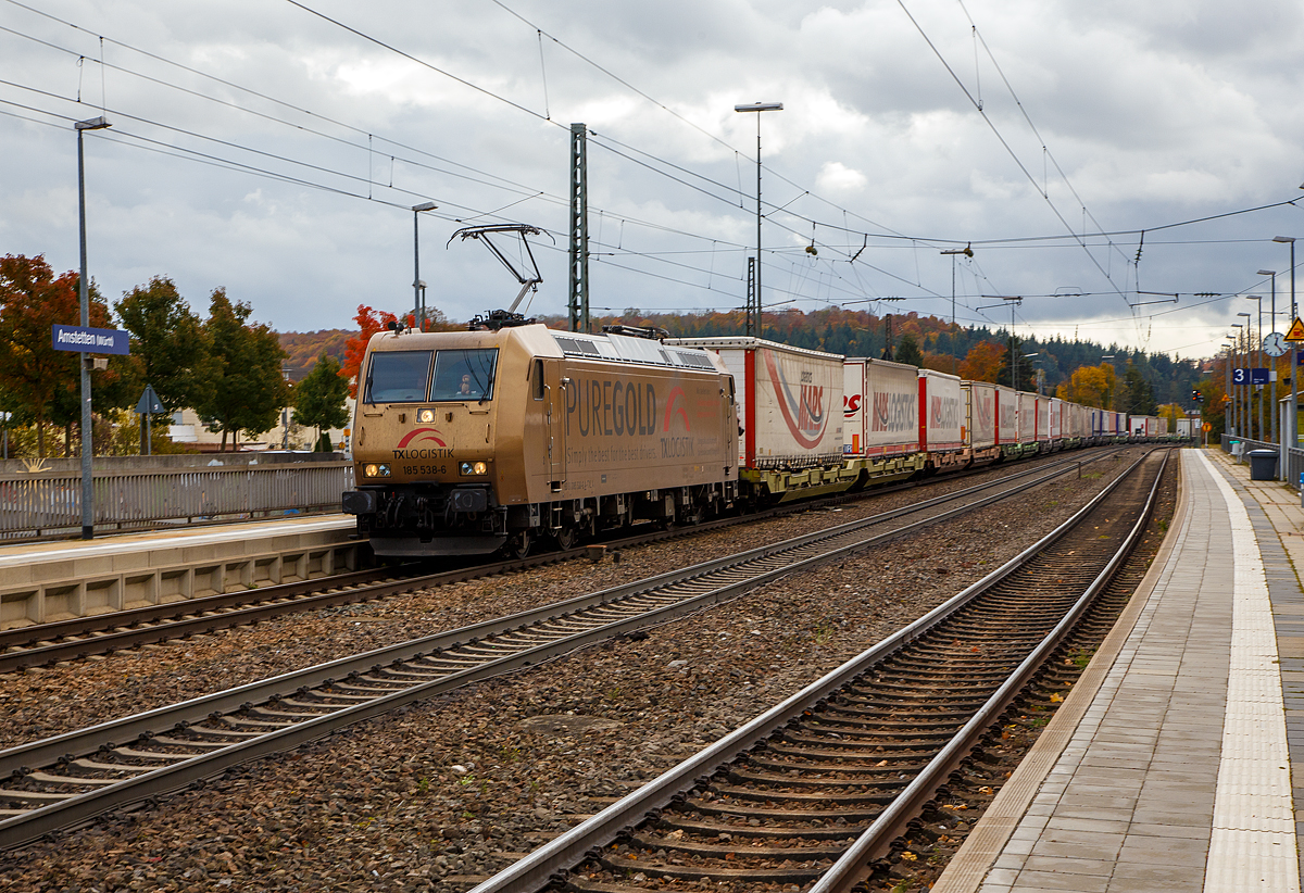 Die TX Logistik 185 538-6 (93 81 0185 538-6 A-TXLA, ex 91 80 6185 538-6 D-TXL) fhrt am 26.10.2021 mit einem langen KLV-Zug durch den Bahnhof Amstetten (Wrtt) in Richtung Stuttgart. Gleich geht es die berhmte Geislinger Steige hinab. 

Nochmal einen liebe Gru an den netten Lokfhrer zurck, der mich hier mit Lichthupe grte.

Die TRAXX F140 AC wurde 2004 bei Bombardier in Kassel unter der Fabriknummer 33657 gebaut. Sie hat die Zulassungen fr Deutschland und sterreich. Die Lok trgt die Werbung PUREGOLD fr die TX Logistik.