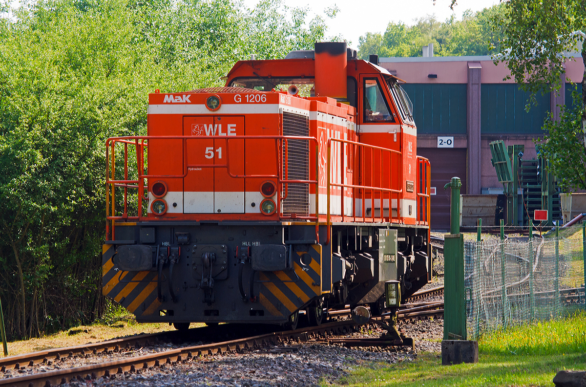 
Die WLE 51  Kreis Warendorf  (Westfälische Landes-Eisenbahn) eine MaK G 1206 steht am 20.05.2014 am dem Werksanschluß der Salzgitter Mannesmann Precision GmbH in Burbach-Holzhausen. 

Die Lok wurde 2002 bei Vossloh unter Fabriknummer 1001150 gebaut. Die komplette NVR-Nummer ist 92 80 1275 106-3 D-WLE, die EBA-Nummer EBA 02L22K 001.

Die Lokomotive MaK G 1206 ist eine dieselhydraulische Lokomotive, die von der Maschinenbau Kiel (MaK), ehemals DWK - Deutsche Werke Kiel, entwickelt wurde. MaK wurde 1998 von Vossloh gekauft und firmiert seither als Vossloh Locomotives. 

Technische Daten der WLE 51
Spurweite: 1.435 mm
Achsfolge	: B´B´
Länge über Puffer: 14.700 mm
Drehzapfenabstand: 7.200 mm
Drehgestellachsabstand: 2.400 mm
größte Breite: 3.080 mm
Höhe über Schienenoberkante: 4.220 mm
Raddurchmesser neu: 1.000 mm
kleinster befahrbarer Gleisbogen:	60 m
Dienstgewicht: 87,3 t
Kraftstoffvorrat: 3.500 l
	
Motor: 
Caterpillar 12 Zylinder 4-Takt Dieselmotor mit Abgasturbolader und Ladeluftkühlung vom Typ 3512B DI TA mit einer Leistung von 1.500 kW bei1.800 U/min
	
Strömungsgetriebe: Voith L5r4zU2
Höchstgeschwindigkeit	100 km/h
max. Schleppgeschwindigkeit : 80 km/h
kleinste Dauerfahrgeschwindigkeit: 10 km/h

Die MaK G 1206 ist im schweren Rangier- und Streckendienst einsetzbar. Sie wurde 1997 zum ersten Mal gebaut und ist nach Deutschland, Österreich, der Schweiz, Luxemburg, Italien, Spanien, den Niederlanden und nach Frankreich verkauft worden. Allein 23 Lokomotiven fahren als BB 61000 bei der SNCF, davon sechs mit MTU-Motor (Die G 1206 gibt es wahlweise mit Caterpillar- oder MTU-Motor).

Eine Weiterentwicklung der MAK 1206 ist die Vossloh G 1700 BB. In erster Linie wurde dabei der Rahmen so geändert, dass die Vossloh Standarddrehgestelle verwendet werden konnten. Motorisiert wurden die Loks mit dem MTU 12V 4000 R20 mit einer unveränderten Leistung von 1500 kW.

Bei der G 1700-2 BB dagegen handelt es sich um eine komplette Neuentwicklung. Die G 1206-2 ist hingegen eine für den Rangierdienst modifizierte Version der ursprünglichen G 1206. Sie ist mit Caterpillar-Motoren mit lediglich 920 kW und entsprechend kleineren Voith-Getrieben ausgestattet. Ihre Höchstgeschwindigkeit ist auf 50 km/h reduziert worden.
