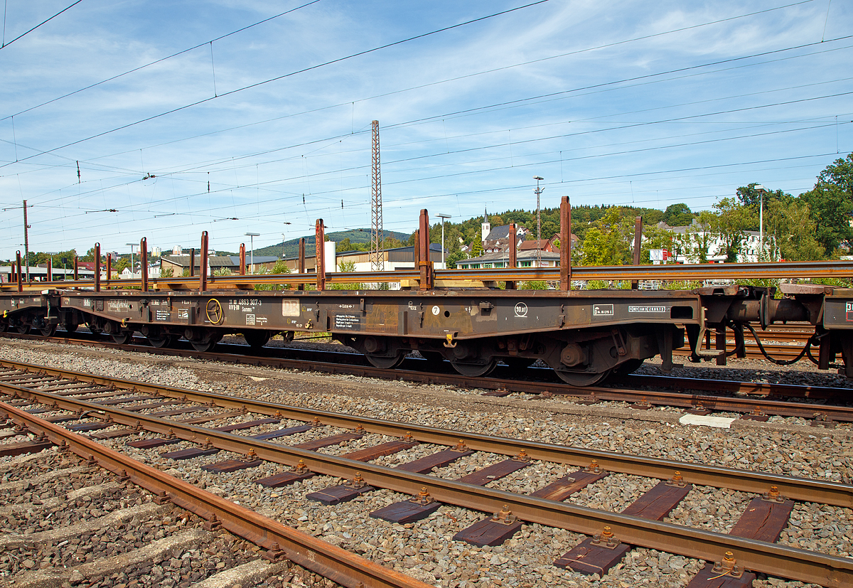 Drehgestellflachwagen mit sechs Radstzen und Lademulden fr Coiltransporte, der Gattung Samms 710, (31 80 4863 307-3 D-DB) am 12.08.2018 abgestellt in Kreuztal. 

Zwischen 1963 und 1977 beschafft die DB insgesamt 3.850 Drehgestell-Flachwagen fr die Befrderung schwerer Walzprofile oder anderer sperriger Gter sowie schwerer Kettenfahrzeuge. Dieser hier wurde 1976 von LHB Linke-Hofmann-Busch GmbH in Salzgitter-Watenstedt unter der Fabriknummer 227 gebaut. 

Der Wagen dient mit aufgeklappten Ladeschwellen zur Befrderung von schweren Walzprofilen und anderen sperrigen Gtern. 
Die Wagenbrcke ist eine in Rahmenbauweise ausgefhrte Schweikonstruktion, deren Hauptbauteile aus St 52 bestehen. Die Hauptbelastungen werden von den ueren Langtrgern aus IP 550 aufgenommen. Die Puffertrger sind so ausgebildet, dass spter ohne groe nderungen die AK eingebaut werden kann.
Der Fuboden besteht aus Kiefernbohlen mit den Abmessungen 70 x 180 mm; er kann eine Radlast von 5,0 t aufnehmen. Im Fuboden sind 6 geteilte klappbare Ladeschwellen eingebaut. Das Fahrzeug hat auf jeder Lngsseite 6 Einsteckrungen und an jeder Stirnseite je 2 versenkbare Rungen (Fallrungen). Die Stirnwandklappen sind umlegbar.
Die Einsteckrungen lagern, wenn sie nicht gebraucht werden, in Taschen an den Auenlangtrgern. Die abgesenkten Fallrungen liegen noch innerhalb des Umgrenzungsprofils, so dass der Wagen auch mit abgesenkten Fallrungen und umgelegten Stirnwandklappen gefahren werden kann. Die bodenbedienbare Feststellbremse wirkt nur auf ein Drehgestell. Der Wagen hat eine geteilte Zugeinrichtung und Hochleistungspuffer.

TECHNISCHE DATEN:
Gattung: Samms 710 (Gattungskennzahl 4863)
Spurweite: 1.435 mm (Normalspur)
Lnge ber Puffer: 	16.400 mm
Drehzapfenabstand: 8.400 mm
Radsatzstand in den Drehgestellen: 2 x 1.700 mm = 3.400 mm
Raddurchmesser: 920 mm (neu) 
Drehgestell-Bauart: 710
Ladelnge: 15.000 	mm
Ladebreite: 2.560 mm
Fubodenhhe ber SO: 1.300 mm
Ladeflche:  45,7 m
Eigengewicht: 29.670 kg 
Zuladung bei Lastgrenze S: 75 t (ab Streckenklasse D) 
Max. Zuladung Streckenklasse CE bei max.100 km/h:  90 t 
Max. Geschwindigkeit: 120 km/h
Kleinster Gleisbogenhalbmesser:	80 m
Bauart der Bremse: KE-GP
Handbremse: 	Fbr
Verwendungsfhigkeit: RIV
