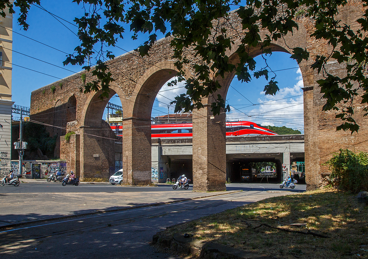 Durch das Aquädukt („römische Wasserleitung“) bei der Porta Maggiore (italienisch größeres Tor) in Rom geschaut....
Oben erreicht am 13.07.2022 ein Trenitalia Frecciarossa 1000 (ETR 400) den Bahnhof Roma Termini, während unten der achtachsige fünfgliedrige Cityway I Gelenktriebwagen ATAC 9101 (Azienda per i Trasporti Autoferrotranviari del Comune di Roma) als Linie 3 bald die Zielstation Porta Maggiore erreicht.
