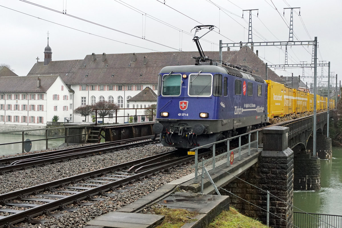 Ehemalige  MNCHNERIN  im Gterverkehr.
Re 421 371-6 mit einem Postzug vor der herrlichen Kulisse des alten Spitals beim Passieren der Aarebrcke Solothurn am 2. Februar 2021.
Von den  Dunkelblauen  befinden sich nur noch die Re 421 371-6 und Re 421 383-1 in einem betriebstchtigen Zugen. Die restlichen Re 421 warten bereits auf die baldige Verschrottung.
Foto: Walter Ruetsch