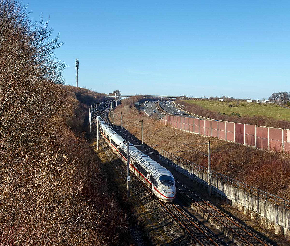 Ein ICE 3 (BR 403) rauscht am 21.02.2021 bei Oberpleis über die Schnellfahrstrecke Rhein/Main (KBS 472) in Richtung Frankfurt am Main. Rechts die Autobahn A 3. Oberpleis ist ein Stadtteil von Königswinter, der auf der dem Rhein abgewandten Seite des Siebengebirges im Pleiser Hügelland liegt.