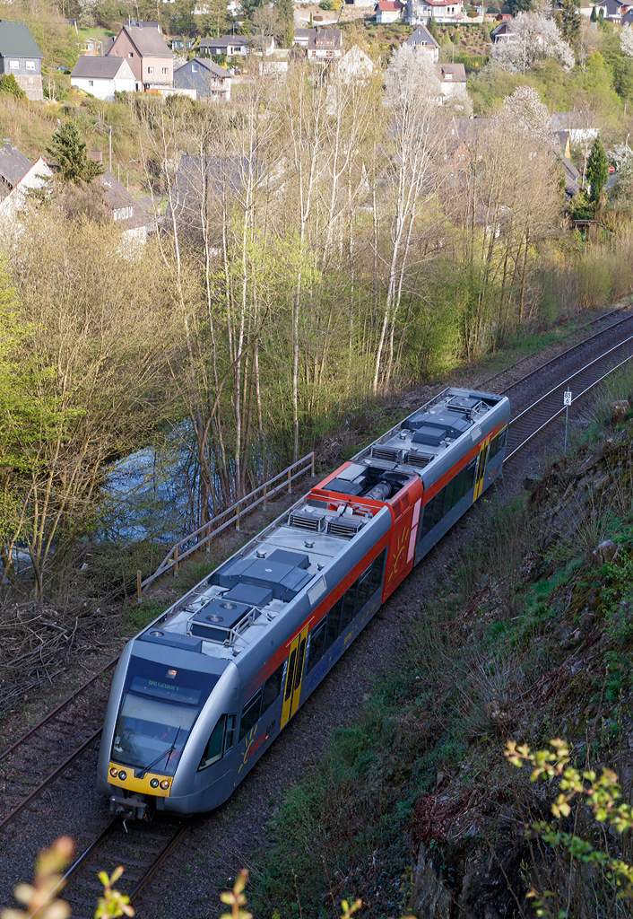 
Ein Stadler GTW 2/6 der Hellertalbahn als RB 96  Hellertalbahn  (Neunkirchen-Herdorf-Betzdorf/Sieg) hat am 24.04.2015 gerade den Hp Grünebach Ort verlassen und fährt nun weiter in Richtung Betzdorf.  

Neben dem noch aktiven Gleis der KBS 462 (Hellertalbahn), liegt hier noch das alte zweite Gleis, der einstigen zweigleisigen Hauptstrecke. Durch die Bäume hindurch noch zuerkennen, verläuft hier neben der Strecke die Heller. 
