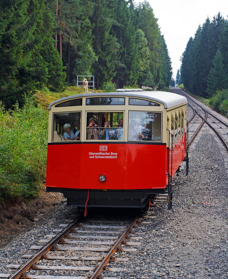 Fahrt mit der Oberweibacher Bergbahn am 24.08.2013, der Wagen 1 - der Personenwagen der Standseilbahn befindet sich auf Talfahrt und kommt uns in der Mitte (zwischen Obstfelderschmiede und Lichtenhain) entgegen.

Der Personenwagen, im betrieblichen Umgang als Wagen 1 bezeichnet, ist seit der Erffnung 1923 nur an den Stirnseiten leicht verndert worden. Das erfolgte 1959, als er grere Stirnfenster erhielt und die leicht ausgestellte Stirnpartie. Bei der Rekonstruktion  2002 wurde die Fahrradbhne angebaut. Besonderheit, sie ist nur am Fahrgestell befestigt und kann 8 Fahrrder aufnehmen.

Bergbahntechnik einer ganz besonderen Standseilbahn
Die Bergbahn besteht aus zwei Teilen:
- der Standseilbahn, von Obstfelderschmiede nach Lichtenhain und
- der  Flachstrecke  der Bergbahn, von Lichtenhain nach Cursdorf

Die Konzession zum Bau wurde fr eine Eisenbahnstrecke von Obstfelderschmiede nach Cursdorf erteilt, heute als Strecke Nr. 6691, KBS 563, der Deutschen Bahn AG gefhrt. Die Standseilbahn ist also ein Bestandteil dieser Eisenbahnstrecke.
 Die Standseilbahn hat zwei unterschiedliche Fahrzeuge, einen “Personenwagen” und eine “Gterbhne” zum Transport normalspuriger Eisenbahnwagen bis 27 t Gesamtmasse.
Sie wurde gebaut fr den Gterverkehr, um die Hochebene um Oberweibach an das deutsche Eisenbahn-Netz anzuschlieen.
 
Statt Gterwagen, ist heute in der Regel ein ehemaliger Triebwagen-Beiwagen oder das  Cabrio , ein offener Wagen, auf der Gterbhne aufgesetzt.
Die  Strecke ist eingleisig und hat eine Abt´sche Ausweiche in der Mitte, wo beide Wagen aneinander vorbei fahren. Eine weitere Abt’sche Weiche in der Talstation trennt die Strecke in zwei Gleise, um den Personenwagen an den Bahnsteig und die Gterbhne an die Verladerampe zu leiten.
Die Standseilbahn hat an beiden Enden jeweils Anschlu ber eine Drehscheibe an die Bahnanlagen mit Regelspur-Gleisen.

Quelle: http://www.oberweissbacher-bergbahn.com/de/obs-info
