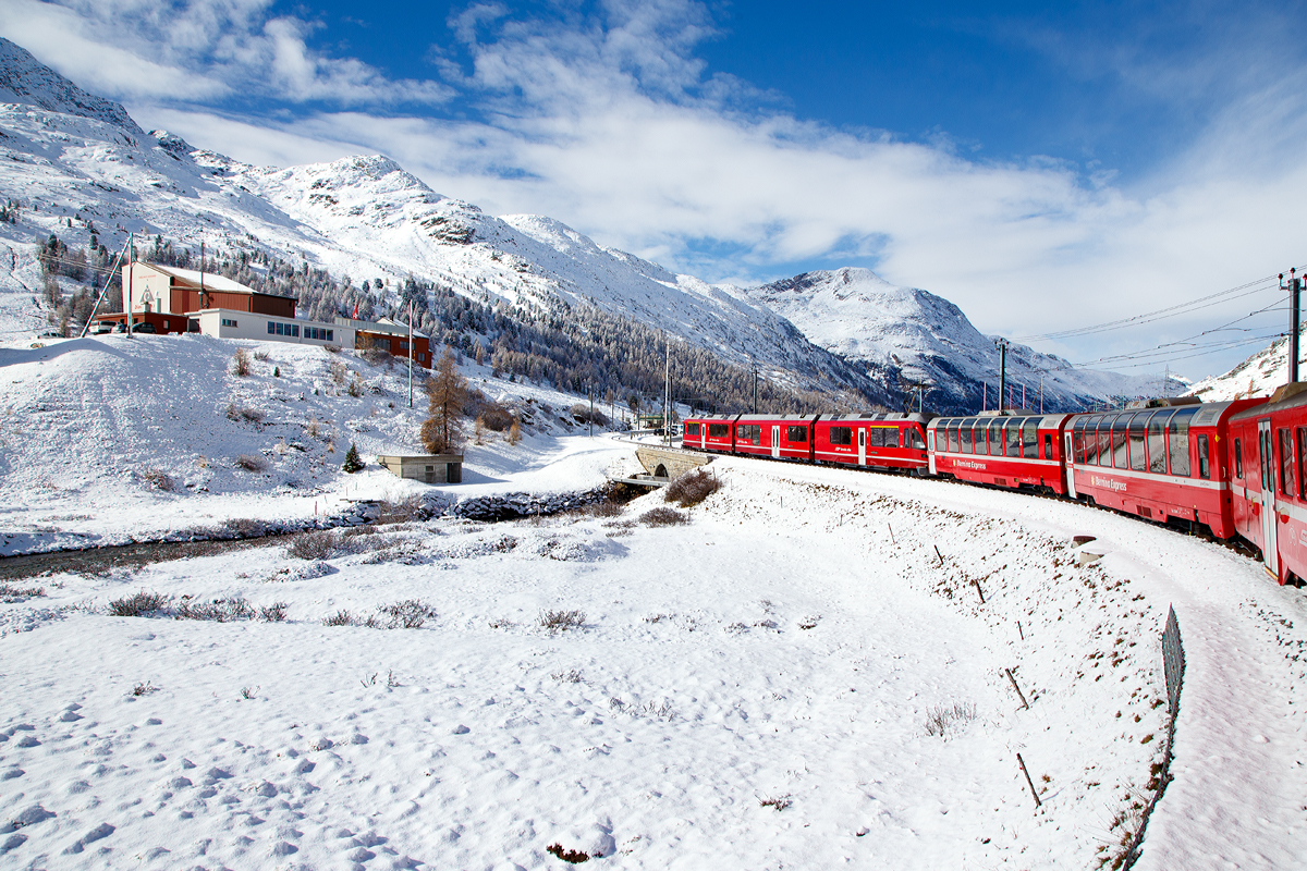 
Geführt von dem ALLEGRA-Zweispannungstriebzug RhB ABe 8/12 – 3501 „Willem Jan Holsboer „ erreicht am 04.11.2019  unser RhB Regionalzug von Tirano nach St. Moritz, nun Haltestelle Bernina Diavolezza. 
Links die Talstation (2.096 m ü. M.) der Kabinenseilbahn Diavolezza (Teufelin).
