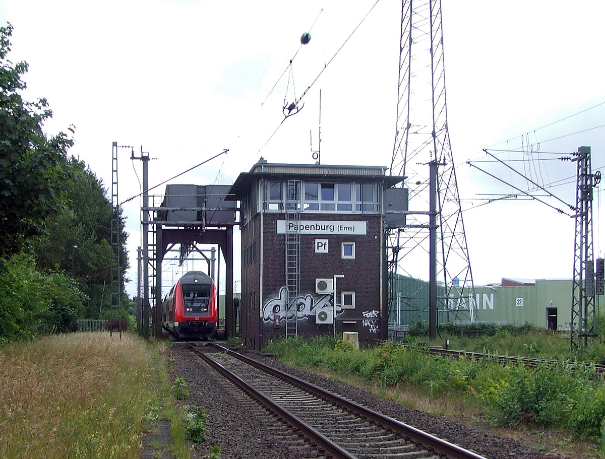 
Gleich vor dem Bahnhof Papenburg (Ems) befindet sich die Eisenbahnklappbrücke über den Papenburger Sielkanal, davor noch das Fahrdienstleiterstellwerk Papenburg (Ems) „Pf“, hier am 20.06.2009.

Die beiden Brückenteile sind nun unten und der RE kann den Bahnhof anfahren.