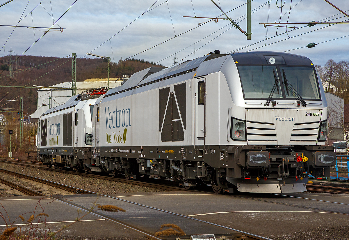 Hat da jemand vielleicht die Stromrechnung nicht bezahlt.... 
Denn die beiden Siemens Vectron Dual Mode Loks, 248 004 (90 80 2248 004-4 D-SIEAG) und die 248 003 (90 80 2248 003-6 D-SIEAG) der Siemens Mobility GmbH, fahren am 20.03.2021, mit abgesenkten Stromabnehmern als Lokzug, obwohl die Strecke elektrifiziert ist, über die Siegstrecke (KBS 460) durch Niederschelden in Richtung Siegen. 

Beide Vectron DM wurden 2020 von Siemens Mobility GmbH in München-Allach gebaut, die 248 004 unter der Fabriknummer 22927 und die 248 003 unter der Fabriknummer 22926. Am 29. Oktober 2020 wurde vom Eisenbahn-Bundesamt (EBA) die Zulassung für den Betrieb der Siemens Vectron Dual Mode Loks in Deutschland erteilt. Einige Unternehmen haben sie auch schon bestellt. Auch die DB Cargo bestellte 100 Zweikraftlokomotiven im September 2020 der auf Basis der Baureihe 248, mit einer Option über weitere 300 Loks. Die Auslieferung startet ab 2023. Die DB Loks sind aber stark modifiziert, so soll bei ihnen die Achslast maximal 21 t betragen (statt 22,5 t).

Hybrid muss nicht immer Akkunutzung heißen. Siemens neue Vectron hat neben der Elektrofähigkeit unter Fahrdraht auch einen Dieselmotor.

Der Vectron Dual Mode vereint die Vorteile einer vollwertigen Diesellokomotive mit denen von elektrischen Lokomotiven. Dank des leistungsstarken Dieselantriebs sowie der Ausstattung für die Nutzung der Fahrleitung kann man jederzeit flexibel auf die Traktionsanforderungen reagieren. So bleibt man immer in Bewegung, egal ob mit oder ohne Fahrdraht. Wo ein Fahrdraht ist, sollte man ihn nutzen. Denn der Betrieb unter Oberleitung ist im Vergleich zum Dieselbetrieb deutlich kosteneffizienter und umweltfreundlicher. Doch weil es in Deutschland noch lange Zeit Strecken geben wird, die nicht vollständig elektrifiziert sind, fahren viele Diesellokomotiven unter Fahrdraht weiter. Das ist aber ökonomisch und ökologisch wenig sinnvoll. Dies ist hier ein Beispiel einer echten Alternative. 

Mit der Vectron Dual Mode ist es möglich Güterzüge aus dem Umland umweltschonend in die Zentren der Ballungsräume zu befördern. Nur so einfach, wie in der Siemens Werbung ist es auch nicht, denn die Lok vier Achsen (Bo’Bo’) und wiegt 90 t, so ergibt sich eine Achslast  von 22,5 t. Nicht elektrifizierte Nebenstrecken haben nicht gerade alle von min. D2 (22,5 t), und können so auch nicht befahren werden. Auch die Leistung der DM im Vergleich zu heutigen Hochleistungselektrolokomotiven ist mit 2.400 kW erheblich geringer. Mit den Dieselstreckenlos kann sie aber mit 2.000 kW sehr gut mithalten, zudem liegt die Anfahrzugskraft bei stattlichen 300 kN.

TECHNISCHE DATEN der Siemens Vectron Dual Mode (BR 248)
Spurweite: 1.435 mm
Achsformel: Bo'Bo'
Länge über Puffer: 19.975 mm
Drehzapfenabstand: 10.800 mm
Achsabstand im Drehgestell: 2.700 mm
Breite: 3.020mm
Höhe:  4.220 mm
Raddurchmesser :  1.100 mm (neu) / 1.020 mm (abgenutzt)
Gewicht:  90 t (bei vollen Vorräten)
Achslast: 22,5 t
Spannungssysteme (bei E-Betrieb): 15 kV, 16,7 Hz
Dieselmotor: MTU 16V 4000 R84 (16-Zylinder-V-Motor)
Dieselmotorleistung an der Kurbelwelle: 2.400 kW
Max. Leistung am Rad: 2.400 kW bei E-Antrieb / 2.000 kW bei D-Antrieb
Höchstgeschwindigkeit:160 km/h
Antriebsart: elektrisch oder dieselelektrisch
Kraftübertragung :Teilabgefederter Antrieb (Ritzelhohlwellenantrieb)
Kraftstoffbehälter Nutzvolumen: 2.600 l
Anfahrzugskraft:  300 kN
Elektrische Bremskraft: 150 kN
Elektrische Bremsleistung (am Rad): E-Betrieb 2.100 kW / Dieselbetrieb 1.700 kW
Doppeltraktion: Über WTB ÖBB mit typgleichen Fahrzeugen sowie Vectron E, Vectron DE und ER20
Zugsicherung: PZB / für ETCS vorbereitet
