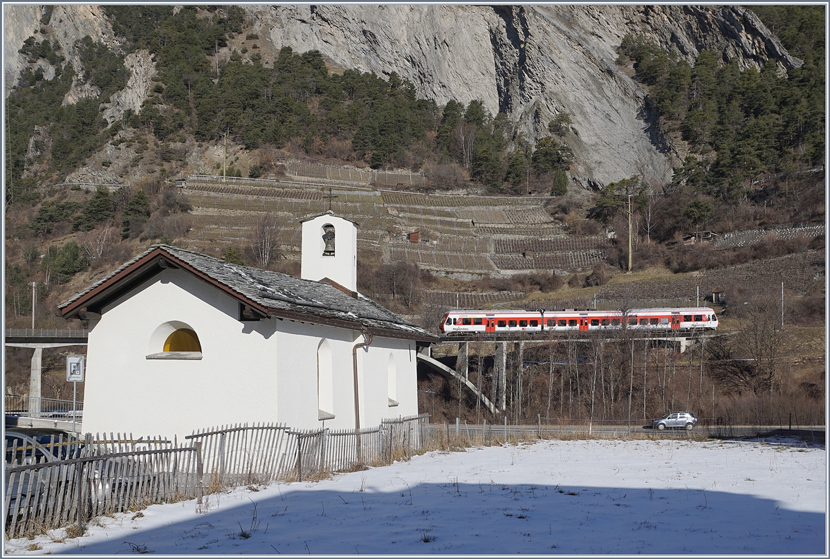 Im Vordergrund die aus dem Jahre 1445 stammende Chapelle des Sept Joies (die Sieben Freuden Marias) in Sembrancher und im Hintergrund ein RegionAlps RABe 525 als TMR Regionalzug 26118 auf dem Weg von Martigny nach Le Châble.

9. Februar 2020