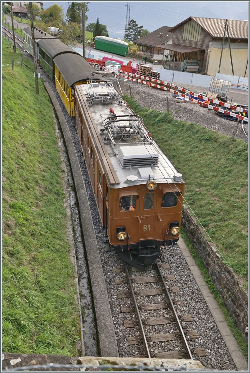  La DER de la Saison 2023  - die Bernina Bahn RhB Ge 4/4 81 der Blonay-Chamby Bahn mit dem  Velours -Express von Chaulin nach Vevey bei Cornaux unmittelbar vor der Einfahrt in den  Baye de Clarens Schlucht  Tunnel, dessen Krone am unteren Bildrand zu sehen ist. Das Bild wurde nicht entzerrt, da sonst ein beträchtlicher Teil des Zuges verloren gegangne wäre. 

29. Okt. 2023