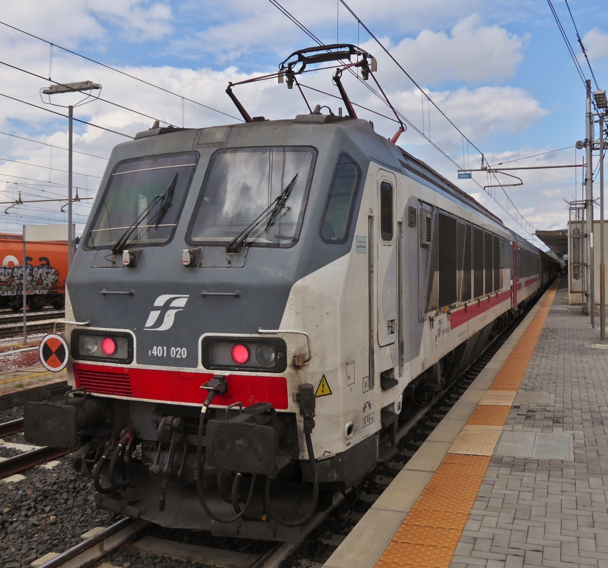 Lok E401 020 schiebt ihren Intercity Zug nach einem kurzen Halt aus dem Bahnhof von Ferrara. 08.05.2025