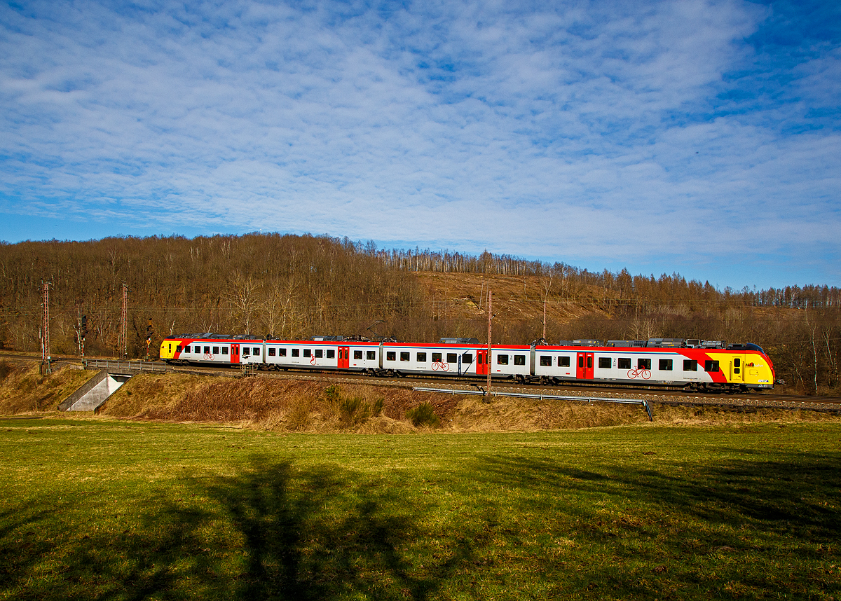 Man sieht nun auch vierteilige HLB  Grinsekatzen  auf der Dillstrecke....
Der ET 157 (94 80 1440 657-3 D-HEB / 94 80 1441 657-2 D-HEB / 94 80 1441 157-3 D-HEB / 94 80 1440 157-4 D-HEB) ein vierteiliger Niederflur-Elektrotriebwagen vom Typ Alstom Coradia Continental der HLB (Hessische Landesbahn), fährt am 02.03.2022 als RE 99 (Gießen - Siegen) und erreicht bald den Hp Rudersdorf (Kr. Siegen).

Der vierteilige Niederflur-Elektrotriebwagen wurde 2018 von ALSTOM Transport Deutschland GmbH in Salzgitter unter den Fabriknummer D041531-004 (A1, B, C und A2) gebaut und an die HLB geliefert. 

Die Triebzüge Alstom Coradia Continental gehören zur Fahrzeugfamilie modularer, niederfluriger elektrischer Nahverkehrs-Gliedertriebzüge Alstom Coradia. Die Züge werden aus einem Baukasten standardisierter Einzelfahrzeuge gebildet, die ihre technische Ausrüstung mit Ausnahme der Fahrmotoren auf dem Dach tragen. Die Endwagen tragen jeweils einen Haupttransformator, einen Antriebsumrichter und einen Nebenbetriebsumrichter. Die Mittelwagen tragen die weiteren Ausrüstungen Stromabnehmer, Kompressor und Batteriekasten. Mittig auf jedem Fahrzeug ist das Klimagerät für den Fahrgastraum angeordnet.

Die Hessische Landesbahn hat insgesamt 30 dieser neuen Niederflur-Elektrotriebzüge gekauft, 17 vierteilige und 13 dreiteilige ET. Am 27. Juli 2018 erhielten die Züge ihre Zulassung und werden seitdem Probebetrieb eingesetzt. Zudem wurden noch 5 weitere bestellt.

Die Züge erreichen im Einsatz Geschwindigkeiten von bis zu 160 km/h und besitzen ein sehr gutes Beschleunigungsvermögen. Sie können je nach Fahrgastaufkommen auch in Doppeltraktion betrieben werden. Durch ein speziell für Regionalzüge modifiziertes Zugsicherungssystem können die Fahrzeuge auch auf ICE-Strecken fahren. Die Triebzüge sind zudem mit elektrischen Bremsen ausgestattet, die in der Lage sind, beim Bremsvorgang bis zu 30 Prozent der Energie ins Netz zurück zu speisen.

TECHNISCHE DATEN der BR 1440.1:
Hersteller: Alstom Transport Deutschland GmbH
Spurweite: 1.435 mm
Achsfolge: Bo‘(Bo‘)(2’ )(Bo‘)Bo‘ in Klammern Jakobs-Drehgestelle
Länge über Kupplung: 73.300 mm
Breite: 2.920 mm
Drehzapfenabstände: 15.500 / 16.400 / 16.400 / 15.500 mm
Achsabstand im Enddrehgestell: 2.400 mm
Achsabstand im Drehgestell: 2.700 mm
Maximale Höhe (über SO): 4.280 mm
Eigengewicht: 144 t
Minimaler befahrbarer Gleisbogen Werkstatt/Betrieb: 100/150 m
Niederfluranteil: ca. 89 %
Sitzplätze: 227 (davon 12 in der 1. Klasse)
Stromsystem: 15 kV / 16,7 Hz
Höchstgeschwindigkeit: 160 km/h
Nennleistung: 2.900 kW
Anzahl Fahrmotoren: 8
Zugbeeinflussungs-System: LZB / PZB 90
