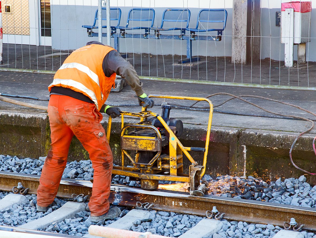 
Mittels einer Giesmar Schienenprofilschleifmaschine vom Typ MP 6 werden am 12.11.2016 im Bahnhof Betzdorf/Sieg am Gleis 105 nach dem Thermitschweien noch die Schienenste geschliffen. 

Technische Beschreibung 
Die Maschine dient zum przisen Schleifen von Schweisten an den Schienenlaufflchen und -fahrkanten, sowie zum Schleifen von Auftragsschweiungen.
 
Der als Schweikonstruktion in Leichtbauweiseausgefhrte Maschinenrahmen besitzt fhrungspraktische Griffe, sowie einen klappbaren Fhrungsbgel. Hierdurch lt sich die Maschine vom Bediener whrend des Schleifprozesses, bequem und praktisch handhaben. Mittels eines Fuhebels lsst sich der Klappbgel leicht entriegeln und somit die Maschine fr den Fahrkanten- und Flankenschliff abklappen. Ein besonderes Fhrungsrollensystem an beiden Maschinenenden ermglicht die Einstellung von drei verschiedenen Fhrungspositionen. Hierdurch wird die Maschine gewichtsentlastend beim Flankenschliff im Stobereich gefhrt. Mittels zweier verstellbarer Spurkranzfhrungsrollen wird die Maschine beim Herzstckschliff wechselweise an der Herzstck- bzw. Schienenflanke oder an der Flgelschiene vom Bediener mhelos gefhrt. 

Der Schleifkopf bewegt sich immer rechtwinklig zur Schiene und kann je nach Abnutzung nachgestellt werden. Ebenso ist auch der Anstellwinkel der Schleifscheiben nach den betreffenden Arbeitserfordernissen (aggressives oder weniger aggressives Schleifen) einstellbar. Die Schleiftiefeneinstellung wird ber ein zentral angeordnetes Handrad durchgefhrt. Der Bediener hat durch die 
entsprechende Rahmenform eine gute Sicht auf die Schleifstelle. Ein vorschriftsmiger Schleifscheibenschutz ist durch eine einstellbare Schutzhaube gewhrleistet. 

Technische Daten 
Antrieb: luftgekhlter 4-Takt Honda Bezin-Motor 
Abmessungen               
Lnge: 1.065 mm 
Breite:  535 mm 
Hhe: 685 mm 
Gewicht:  52 kg 