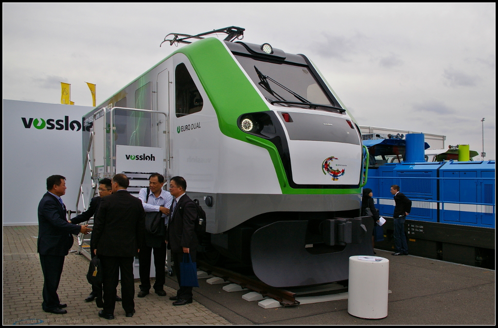 Mockup der Vossloh EURO Dual auf der InnoTrans 2014 in Berlin. Bei dem Loktyp handelt es sich um eine Dual-Mode-Lok mit Elektro- und Dieselmotor. Die EURO Dual basiert auf den beiden Familien EURO 4000 und EUROLight. Angeboten wird die Lok mit drei Diesel-Traktionsklassen (700 kW, 1400 kW und 2800 kW) und elektrisch bis 6000 kW. Die Höchstgeschwindigkeit liegt bei 120 km/h.

Webseite Hersteller (deutsch): http://www.vossloh-innotrans.com/cms/de/produkthighlights/diesellokomotiven/dual_mode_lokomotiven/dual_mode_lokomotiven_1.html