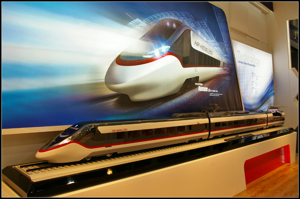 Model of Highspeed train HR-HEMU 250 for South Korea.

Auf dem Messestand von Hyundai Rotem war das Modell des neuen Hochgeschwindigkeitszugs HR-HEMU 250 ausgestellt. Der Zug erreicht eine Höchstgeschwindigkeit von 275 km/h und wird als 6-Wagen- bzw 8-Wagen-Variante ausgeliefert. Das Modell war auf der InnoTrans 2014 in Berlin zu sehen.

Daten: Länge 149 m (6-Wagen) / 198 m (8 Wagen), Kapazität 381 Fahrgäste (6 Wagen) / 533 Fahrgäste (8 Wagen),

Eingesetzt sollen die Züge auf den Strecken Seoul-Gangneung, Seoul-Bujueon, Daegok-Iksan, Pohan-Bujeon, Gwangyang-Bujeon, Suseo-Mungyeong.
