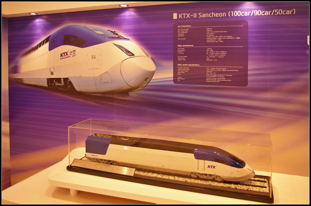 Model of Hyundai KTX Sancheon II for South Korea.

Am Messestand von Hyundai Rotem während der InnoTrans 2014 war auch das Modell des Hochgeschwindigkeitzugs KTX-Sancheon ausgestellt. Der Zug wurde von der KORAIL bestellt und bis 2012 ausgeliefert.

Daten: Höchstgeschwindigkeit 330 km/h, Traktion 10 Wagen pro Zug, Spurbreite 1435 mm, Spannung 25kV / 60 Hz, Gewicht 403 t, Fahrgäste 363.

Webseite Hersteller (english): https://www.hyundai-rotem.co.kr/Eng/Business/Rail/Business_Record_View.asp?brid=59&ref=d1%3D1%26d2%3D1%26d3%3D2
