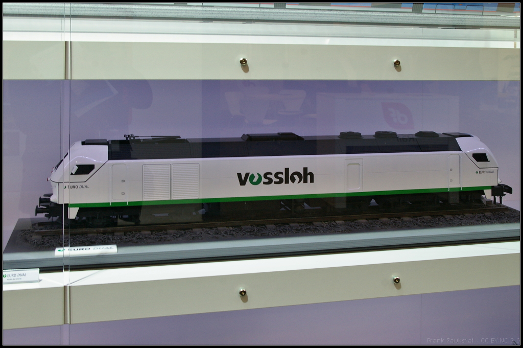 Model of Vossloh EURODual at InnoTrans 2014 in Berlin.
<br /><br />
Am Messestand von Vossloh Rail Vehicles war auch ein Modell der EURODual zu sehen. Die Lok basiert auf der EURO 4000 und der EUROLight. Sie bietet drei Diesel-Traktionsklassen und eine elektrische Leistung bis zu 6000 kW. Das Modell war w�hrend der InnoTrans 2014 in Berlin ausgestellt.
<br /><br />
Webseite Produkt (deutsch): http://www.vossloh-innotrans.com/cms/de/produkthighlights/diesellokomotiven/dual_mode_lokomotiven/dual_mode_lokomotiven_1.html
