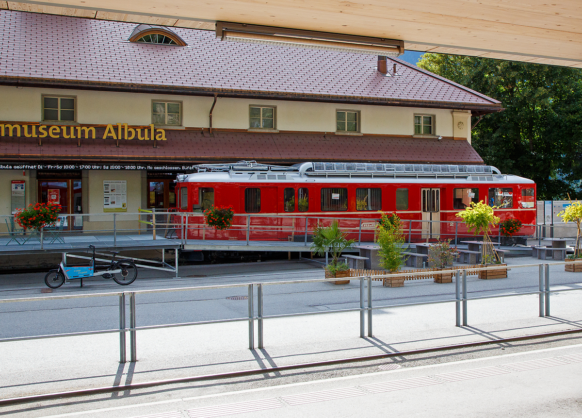 Nun steht er im Bndnerland, vor dem Bahnmuseum Albula in Bergn/Bravuogn.....
Der RhB-Triebwagen BDe 4/4 Nr. 491, ex Misoxerbahn, steht am 06.09.2021 vor dem Bahnmuseum Albula beim Bf Bergn/Bravuogn (aufgenommen aus dem Zug heraus).

Der RhB BDe 4/4 - 491 war der einzige fabrikneu durch die Rhtische Bahn fr die Misoxerbahn bzw. Misoxerlinie  beschaffte Triebwagen (Baujahr 1958 von SWS und BBC) und lehnte sich technisch an die hnlichen, ein Jahr zuvor fr die 2400 Volt-Gleichstrom Strecke Chur - Arosa beschafften Triebwagen ABDe 4/4 Nr. 481-486 an. Die Misoxerbahn war eine ehemalige meterspurige Schmalspurbahn in den Schweizer Kantonen Tessin und Graubnden. Die 31,3 Kilometer lange Strecke fhrte von der Tessiner Kantonshauptstadt Bellinzona durch die Bndner Talschaft Misox nach Mesocco. Erffnet wurde die Strecke 1907 von der Societ Ferrovia elettrica Bellinzona–Mesocco (BM), das 1942 in der RhB aufging. Bereits 1972 wurde der Personenverkehr eingestellt, 2003 auch der Gterverkehr. Bis 2013 wurde auf dem verbliebenen 12,7 Kilometer langen Reststck durch die Societ Esercizio Ferroviario Turistico (SEFT) ein touristischer Museumsbahnbetrieb aufrechterhalten und die Eisenbahn als Ferrovia Mesolcinese (FM) bezeichnet. 

Seither war der Triebwagen gemeinsam mit einigen weiteren ex RhB- und ex BA-Fahrzeugen im Depot in einer frheren Fabrikhalle in Grono abgestellt. Aufgrund der nun anstehenden Auflsung der Museums-Sammlung der SEFT in Grono wurden fr die Fahrzeuge neue Standorte gesucht und fr den BDe 4/4 Nr. 491 ein Platz beim ALBULA-Bahnmuseum in Bergn gefunden. In der Folge wurde er auf der Strae von Grono via San Bernardino-Tunnel nach Landquart in die RhB-Haupt-Werksttte berstellt, wo er eine uere Aufarbeitung mit Neulackierung im Stil der 80er-Jahre erhalten hat. Er sieht nun wieder so aus, wie er 1980 die HW-Landquart schon einmal verlassen hatte. Am 9.Juni 2021 wurde er im Rahmen einer Sonderfahrt tagsber, gezogen von einer Diesellok und erstmalig auf Stammnetz-Gleisen nach Thusis und nachts dann weiter nach Bergn berstellt. Dort wird er knftig an die einstige, vom restlichen RhB-Netz isolierte, frhere Misoxer-Bahn weiter erinnern.

Hier wird er in den kommenden Monaten vor dem Eingang des Museums aufgestellt bleiben und als „GROTTO 491“ seine frhere Heimat, das Bndner Sdtal Misox vertreten. Zu einem spteren Zeitpunkt soll der Triebwagen auf das frher von dem Rhtisches Krokodil RhB Ge 6/6 I 407 genutzte Gleis unterhalb des Museums neben der Bahnhofs-Zufahrt aufgestellt werden, wo er sich dann knftig noch besser prsentieren wird und auch frei Fotografieren lsst.

TECHNISCHE DATEN der BDe 4/4:
Anzahl: 1
Hersteller: SWS, BBC
Baujahre: 1958
Spurweite: 1.000 mm (Meterspur)
Achsformel: Bo’Bo’
Lnge ber Puffer: 	17.770 mm
Gesamtradstand: 13.950 mm
Dienstgewicht: 41 t
Hchstgeschwindigkeit: 	65 km/h
Stundenleistung: 677 kW
Anfahrzugkraft: 129 kN
Stundenzugkraft: 62 kN bei 39,5 km/h
Stromsystem: 	1500 Volt DC (Gleichstrom)
Anzahl der Fahrmotoren: 4
bersetzungsverhltnis: 1:4,83
Sitzpltze (2.Klasse): 16 und 4 Klappsitze
Ladeflche: 11 m
