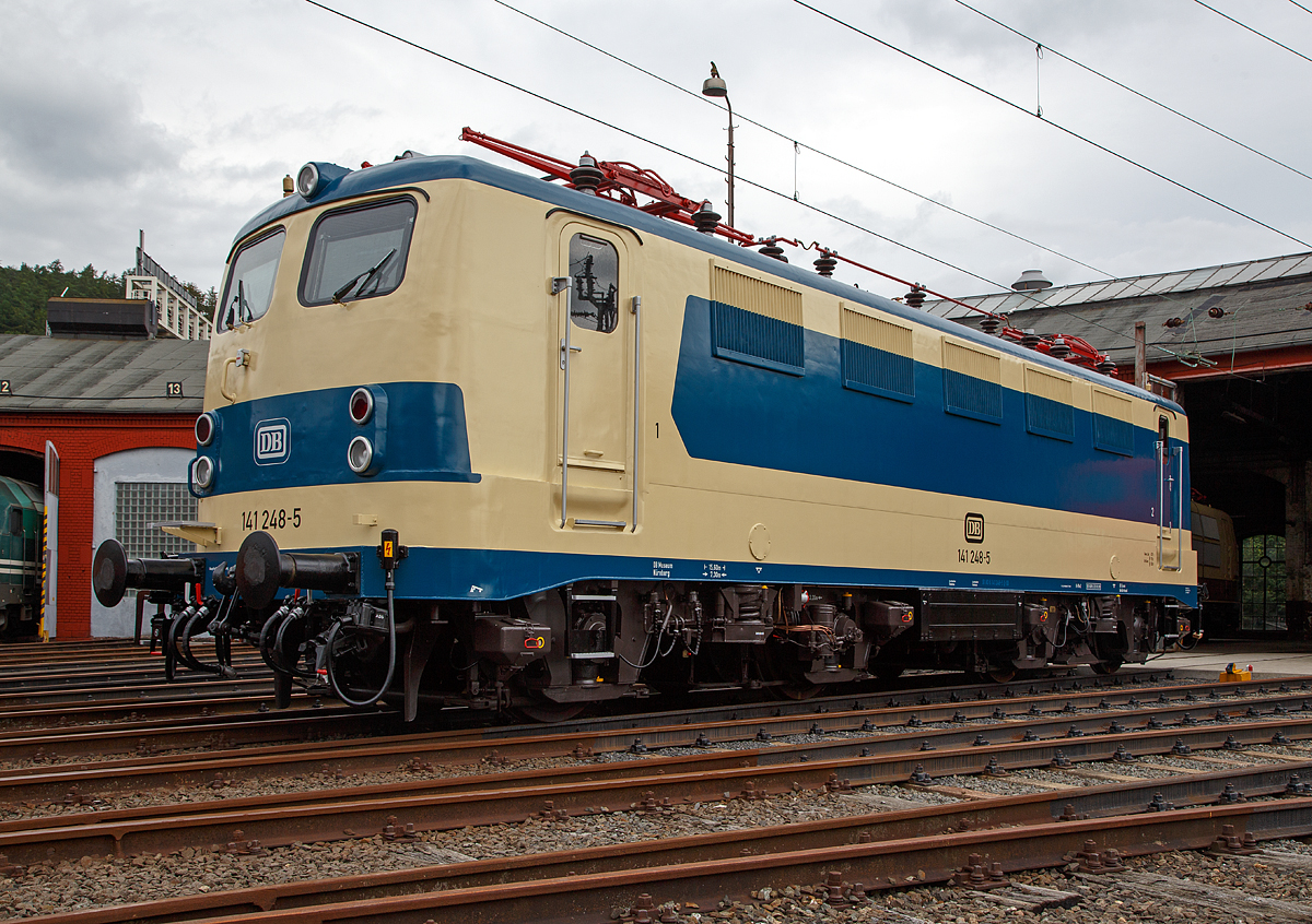 
Nun wieder in der blau/beige Sonderlackierung des  Karlsruher Zuges , diesen trug sie von 1977 bis 2000...........
Die 141 248-5, ex DB E 41 248, wird am 20.08.2016 beim Lokschuppenfest vom Südwestfälischen Eisenbahnmuseums in Siegen vor dem Ringlokschuppen präsentiert. Nach nun nach 16 Jahren in „Verkehrsrot“ wieder  in der Sonderlackierung des  Karlsruher Zuges , so war sie früher auch sehr oft auf der Ruhr-Sieg und der Dill-Strecke zu sehen. Sie war auch die einzige in dieser Versuchslackierung zum Karlsruher Wendezug (grün-beige), diesen trug sie 1977 bis 2000.
 
Die Lok wurde 1963 von Henschel unter der Fabriknummer 30451 gebaut, der elektr. Teil von Brown, Boveri & Cie AG (BBC). Im Jahr 2003 wurde sie z-gestellt, heute ist sie Eigentum vom DB-Museum Nürnberg und eine Leihgabe an das Südwestfälisches Eisembahnmuseum (Bw Siegen).

Von 1977 bis 1995 war der  Knallfrosch“ dem BW Hagen-Eckesey zugeteilt, im Januar 1977 erhielt sie den asymmetrischen S-Bahn-Versuchslack, der der allgemeinen ozeanblau-beigen Farbgebung ähnelt. Die Lok sollte immer mit der gleichen Seite an einem mit blauen Fensterband umgerüsteten Versuchszug der BD Essen aus umgebauten Silberlingwagen für den S-Bahn-Verkehr am Zug hängen, damit Lok und Wagen farblich harmonierten. Dieser Zug, der sogenannte „Karlsruher Zug“, war der Prototyp für die bis heute zahlreich eingesetzten S-Bahn-Züge, gebildet aus Lokomotiven der Baureihen 111 bzw. 143 und drei bis fünf x-Wagen.