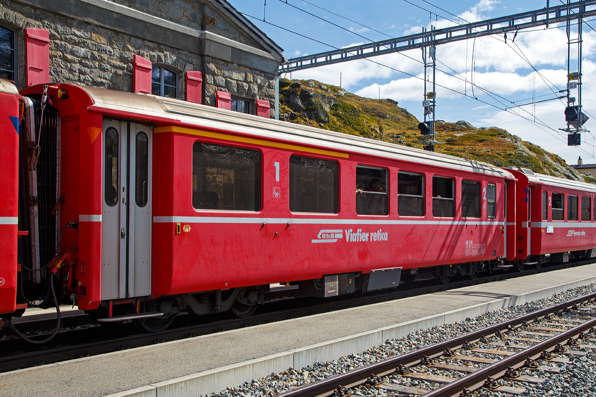 Personenwagen RhB AB 1541 ein verkrzter 1./2.Klasse Einheitswagen I (EW I) mit Aluminiumwagenkasten am 13.09.2017 in der Station Ospizio Bernina im Zugverbund.

Mit mehr als 100 Fahrzeugen bilden die als Einheitswagen I bezeichneten Personenwagen bis heute die grte Serie im Rollmaterialbestand der RhB. Das Fahrzeugkonzept wurde Anfang der sechziger Jahre in enger Zusammenarbeit zwischen Industrie und RhB entwickelt. Als Neuheit galten damals die Einstiegsbereiche mit WC und Stauraum fr sperriges Gepck an den Wagenbergngen. Folglich weicht das Konzept deutlich von den Mitteleinstiegswagen aus den vierziger Jahren ab.

Die ersten von FFA und SIG gebauten Einheitswagen I wurden Ende 1963 in Betrieb genommen. In einem Zeitraum von etwa zehn Jahren wuchs der Bestand an EW I kontinuierlich. Neben den 18,42 m langen Wagen, die hauptschlich auf dem Stammnetz eingesetzt werden, kamen auch Sonderbauformen mit Aluminiumwagenkasten hinzu. Zu diesen zhlen beispielsweise diese auf 14,91 m verkrzten Fahrzeuge fr den Einsatz auf der Berninabahn (wegen zum Teil sehr engen Kurvenradien).


TECHNISCHE DATEN:
Baujahr und Hersteller: 1968 / Flug- und Fahrzeugwerke Altenrhein AG (FFA)
Spurweite: 1.000 mm
Anzahl der Achsen: 4
Lnge ber Puffer: 14.910 mm
Drehgestellart: SWP 68
Sitzpltze: 12 (1.Klasse) / 30 (2.Klasse)
Eigengewicht: 14,0 t
Max. Gesamtgewicht: 17 t
zulssige Geschwindigkeit: 90 km/h
Lauffhig: StN (Stammnetz) / BB (Berniabahn) / MGB (Matterhorn Gotthard Bahn)