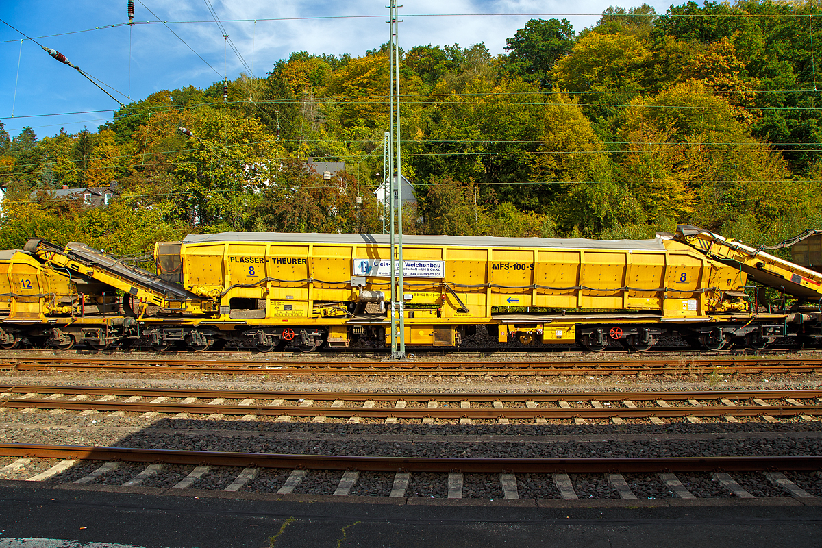 
Plasser & Theurer Materialförder- und Siloeinheit MFS 100 S, Nr. 8 der MGW Gleis- und Weichenbau-Gesellschaft mbH & Co. KG (Berlin), Schweres Nebenfahrzeug Nr. D-MGWB 99 80 9552 112-1(ex 97 19 2955 357 – 4), abgestellt im Zugverband mit der Bettungsreinigungsmaschine RM 95-800 W am 20.09.2020 in Dillenburg. Bei den MFS 100 „S“ ist zudem eine Endladung nach unten ins Gleis möglich.

Die Einheit wurde 2003 von Plasser & Theurer unter der Fabriknummer 4067 gebaut.

Die MFS 100 und dienen zum Transport von Schotter, Abraum und Pufferspeicher bei der Bettungsreinigung bzw. Planumsverbesserung. Hauptvorteil ist der kontinuierliche Förder-, Speicher- und Entladevorgang. Eine Zusammenstellung von beliebig vielen MFS-Wagen zu einem Zug mit jeweils gewünschter Speicherkapazität ist möglich. Der Füllvorgang beginnt beim vordersten Wagen (in Arbeitsrichtung), die folgenden Wagen dienen als Förderstraße.
Eine gleichzeitige Entleerung aller MFS-Wagen durch Ausschwenken der Entladebänder ist möglich, zudem eine dosierte Entladung zum Nachbargleis (Baugleis).

TECHNISCHE DATEN:
Spurweite: 1.435 mm
Achsanzahl : 8 (in 2 Drehgestellen)
Länge über Puffer: 22.900 mm
Länge über Förderband: 26.750 mm
Drehzapfenabstand der Doppeldrehgestelle: 15.100 mm
Drehzapfenabstand der Einzeldrehgestelle: 3.900 mm Achsabstand der Einzeldrehgestelle: 1.500 mm
Höhe:  4.190 mm
Breite:  3.081 mm
Leergewicht: 54 t
Nutzlast:  85 t (ab Streckenklasse D 4)
Raddurchmesser: 730 mm (neu)
Höchstgeschwindigkeit: 100 km/h (beladen / 120 km/h (leer)
Bremse: KP-GE 8x8´
Dieselmotor: wassergekühlter Deutz BF6M 1013 C (für Bandantrieb)
Motorleistung: 165 kW (224,5 PS) bei 2.300 U/min
Minimal befahrbarer Radius 120 m
Förderbandbreiten (Nutzbreite): ca. 1.920 mm 
Schwenkbereich Übergabebande + 47° / - 47°
Siloinhalt (theoretisch): 68 m³
Förderleistung max. (Materialabhängig): 700 bis 800 m³ /h Entladezeit: ca. 5 min 
Bandgeschwindigkeiten Containerband: 1. Gang (Speichern)       ca. 0-0,12 m/s,  2. Gang (Durchfördern) ca. 0-0,43 m/s Übergabeband: konstant 1,30 m/s
