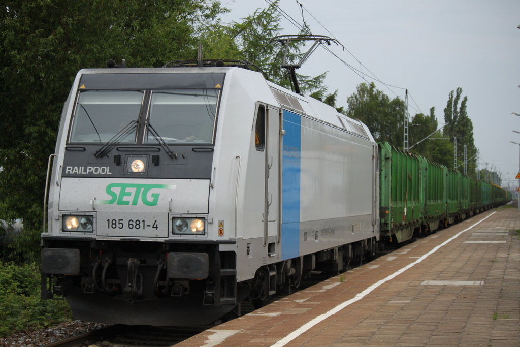 Railpool 185 681-4 SETG  mit Holzzug von Rostock-Bramow nach Stendal-Niederg�rne bei der Durchfahrt im Haltepunkt Rostock-Holbeinplatz.28.05.2015
