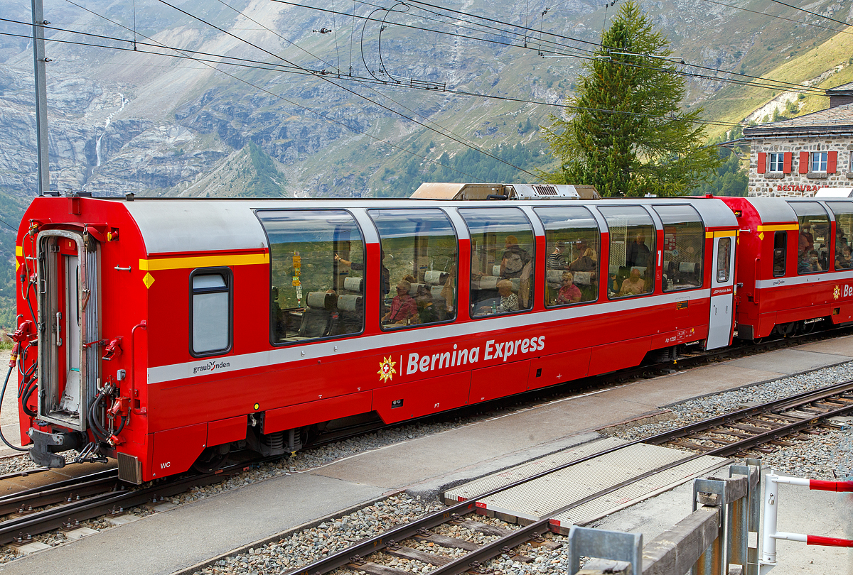 RhB Ap 1292 ein 1.Klasse Bernina-Express Panoramawagen der 1. Serie am 06.09.2021 im Zugverband des Bernina-Express (BEX) nach St.Moritz beim Halt in Alp Grm.

Die Rhtische Bahn verfgt ber einen variantenreichen Wagenpark, zu dem etwa 380 Personenwagen gehren. Die Vielzahl der unterschiedlichen Fahrzeugtypen macht den besonderen Reiz des Rollmaterialbestandes der RhB aus.

Nachdem bereits 1986 die ersten Panoramawagen der Furka-Oberalpbahn (FO) auf dem Netz der RhB zum Einsatz kamen, sah man 1998 bei der RhB den Bedarf, neue Personenwagen zur Erhhung des Fahrgastkomforts anzuschaffen. Nun sollte auch fr den Bernina-Express (BEX) ein Qualittsschub erfolgen. Die Wahl fiel auf moderne Panoramawagen aus dem Baukastensystem der Firma Stadler (ehemalige Schindler Altenrhein). Die RhB bestellte acht Niederflur-Steuerwagen fr den Verkehr ins Unterengadin und 10 Panoramawagen fr den Bernina-Express. Neben den Entwrfen der PA-90-Wagen, die mit der bernahme des Werks Altenrhein von Schindler zu Stadler gewechselt hatten, griff Stadler auf seine Arbeiten zu den GTW-Steuerwagen zurck. So erhielten alle 18 Fahrzeuge eine gemeinsame Basis. Als Drehgestell wurde jedoch weiter der Typ SIG 90 eingebaut. Wegen des Einsatzes ber die Bernina mussten die Wagen verkrzt werden. Gegenber dem Breda-Wagen mussten 3226 mm eingespart werden. Beim Sitzteiler wurden keine Kompromisse gemacht, er betrgt 2.054 mm in der 1. Klasse und 1.782 mm in der 2. Klasse (gleiche Mae wie beim PA-90), hingegen wurde, entsprechend der vllig anderen Kundschaft, weitgehend auf Gepckablagen verzichtet und die Vorrume verkrzt. So konnten dennoch 34 Sitze in erster und 46 Sitze in zweiter Klasse untergebracht werden. Erstmals wurden in einem Panoramawagen nur noch drei Sitze nebeneinander in erster Klasse angeordnet. Auch hier besteht der Wagenkasten aus Aluminium. 

Um den Bernina-Express einheitlich mit Panoramawagen ausrsten zu knnen und zudem ein Angebot Sd-Nord fr italienische Gste aus dem Raum Mailand nach St. Moritz anbieten zu knnen, wurden 2006–2007 noch einmal 16 gleiche Wagen (Api 1301–1306, Bps 2512–2515, Bp 2521–2526) beschafft. Diese erhielten nun allerdings luftgefederte Stadler-Drehgestelle und eine (vakuumgesteuerte) Druckluftbremse, letztere wurde auch bei den bestehenden Wagen nachgerstet. Zudem wurde im Erstklasswagen eine rollstuhlgngige Toilette eingebaut. Da inzwischen das Rauchen in Schweizer Zgen generell verboten wurde, konnte auch auf eine Trennwand fr ein Raucherabteil verzichtet werden, bei den bisherigen Wagen wurde diese entfernt.

Mit den nun 26 Wagen werden vier Zge mit je zwei Wagen erster und vier Wagen zweiter Klasse gebildet, mit denen insgesamt fnf Zugspaare gefahren werden. Seit Inbetriebnahme der Allegras wird der Hauptzug Chur–Tirano und zurck mit sieben Wagen gefahren.

uerlich unterscheiden sich die Panoramawagen 1. Klasse von ihren Schwesterfahrzeugen der 2. Klasse durch eine andere Fenstereinteilung. Statt sieben Panoramafenstern haben die Fahrzeuge der 1. Klasse sechs grere Fenster pro Lngsseite (bei den Wagen der 2. Serie sind es nur 5).

Auch bei der Inneneinrichtung gibt es natrlich Unterschiede: Die Sitze der 1. Klasse sind mit echtem Leder berzogen und etwa 3 cm breiter. Daher weisen die Fahrzeuge eine 2+1 Bestuhlung auf, wohingegen die Panoramawagen der 2. Klasse mit einer 2+2 Bestuhlung ausgerstet sind. Darber hinaus wurde in den Wagen der 1. Klasse ein eleganter Teppichboden verlegt.

TECHNISCHE DATEN Ap-Wagen:
Bezeichnung und Betriebsnummern: Ap 1291 bis Ap 1293
Baujahr: 2000
Hersteller: Stadler
Spurweite: 1.000 mm
Anzahl der Achsen: 4
Drehgestelle: Stadler (Typ SIG 90)
Lnge ber Kupplung: 16.450 mm
Eigengewicht: 19.100 kg
zul. Hchstgeschwindigkeit:100 km/h
Sitzpltze: 34
Lauffhig: StN, BB, MGB
Besonderheiten: Klimaanlage, geschlossenes WC und Panoramafenster mit elektrisch bettigten Rollos