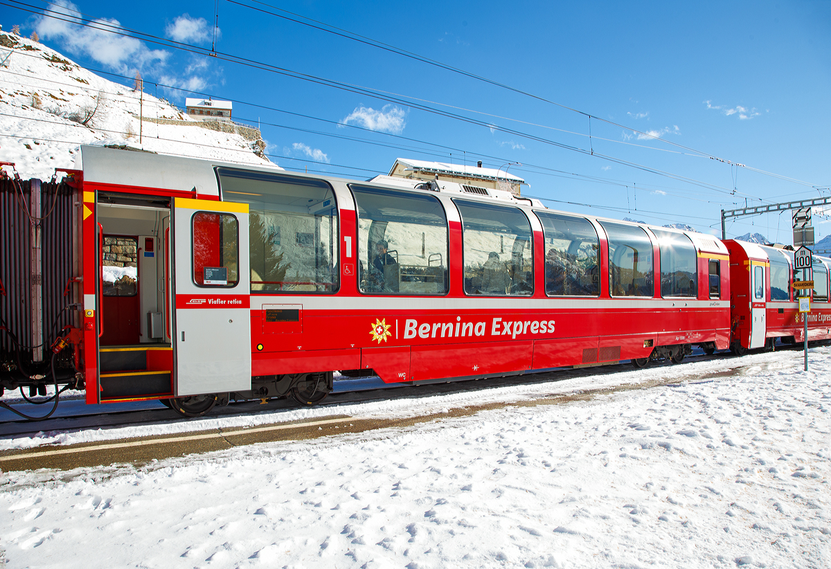 RhB Ap 1306 ein 1.Klasse Bernina-Express Panoramawagen der 2. Serie (Nachbau-Serie) am 04.11.2019, im Zugverband des BEX nach Tirano, beim Halt in Alp Grm.

Fr den berhmten Bernina-Express lie die Rhtische Bahn RhB 26 Panorama-Wagen in zwei Serienbauen. Gegenber den zuvor fr andere Strecken gebauten Wagen, weisen die Bernina-Wagen eine um 3,2 m geringere Gesamtlnge auf. Es entstanden neun 1.Klasse-  und siebzehn 2.Klasse-Wagen, die sich groer Beliebtheit bei den Fahrgsten erfreuen. 

Um den Bernina-Express einheitlich mit Panoramawagen ausrsten zu knnen, wurden 2006–2007 die 2.Serie von 16 Wagen (Api 1301–1306, Bps 2512–2515, Bp 2521–2526) als Nachbauserie beschafft. Diese erhielten nun allerdings luftgefederte Stadler-Drehgestelle und eine (vakuumgesteuerte) Druckluftbremse. Die vakuumgesteuerte Druckluftbremse wurde auch bei den bestehenden Wagen nachgerstet. Zudem wurde im Erstklasswagen eine rollstuhlgngige Toilette eingebaut. Da inzwischen das Rauchen in Schweizer Zgen generell verboten wurde, konnte auch auf eine Trennwand fr ein Raucherabteil verzichtet werden, bei den bisherigen Wagen wurde diese entfernt.

TECHNISCHE DATEN Ap-Wagen:
Baujahr: 2006/2007 
Hersteller: Stadler
Spurweite: 1.000 mm
Anzahl der Achsen: 4
Lnge ber Kupplung: 16.450 mm
Breite: 2.650 mm
Hhe: 3.540 mm
Fubodenhhe: 993 mm
Drehgestellart: luftgefederte Stadler-Drehgestelle
Achsabstand im Drehgestell: 1.800 mm
Laufraddurchmesser: 685 mm (neu)
Sitzpltze: 28
Stehpltze: 57
Eigengewicht: 18 t
Nutzlast: 6,4 t
zulssige Geschwindigkeit: 100 km/h
Lauffhig: StN (Stammnetz) / BB (Berniabahn) / MGB (Matterhorn Gotthard Bahn)