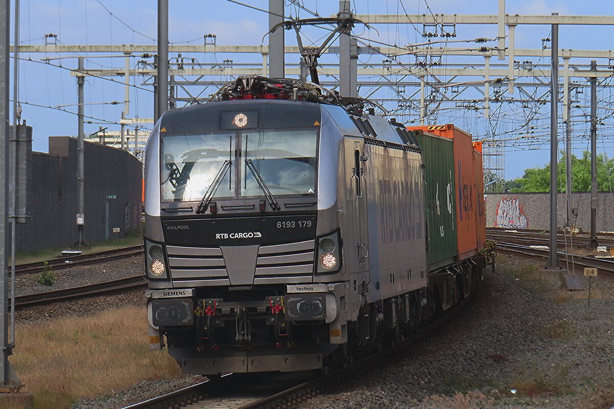 RTB Cargo 193 179 schleppt ein Containerzug durch Breda am 1 Juni 2025 und wird vom Bahnsteig mit etwas zooming fotografiert.