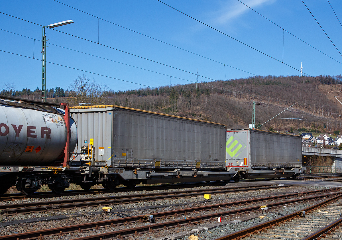 Sechsachsiger Gelenk-Taschenwagen (Doppeltaschenwagen in Gelenkbauart) der Hupac Intermodal SA, 33 85 4956 697-8 CH-HUPAC, der Gattung Sdggmrss am 29.03.2021 im Zugverband bei einer Zugdurchfahrt in Niederschelden.
 
Der Wagen von Tatravagónka a.s. Poprad (Slowakei) unter der Lizenz der Ferriere Cattaneo (Schweiz) gebaut.

Diese Güterwagen sind zum Transport von kranmanipulierbaren Sattelaufliegern und genormten Wechselbehältern / Containern an allen europäischen Eisenbahnstrecken mit Normalspurweite bestimmt.

Technische Daten:
Spurweite: 1.435 mm
Eigengewicht: 36.000 kg
Gewicht des beladenen Wagens: S/SS 135 / 120 t
Max. Radsatzlast S/SS: 22,5 t / 20 t
Max. Ladegewicht S/SS: 99,0 t / 84,0 t
Max. Geschwindigkeit bei Radsatzlast 20 t/22,5 t: 120/100 km/h
Länge über Puffer: 34.200 mm
Drehzapfenabstand: 2 x 14.200 mm
Radsatzstand in den Drehgestellen: 1.800 mm
Ladelänge: 2 x 16.185 mm
Nutzbare Länge des Raums zwischen den Schutzträger: 10.490 mm
Raumbreite zwischen Längsträgern: min. 2 700 mm
Typ der Drehgestelle: 1 x Y25 Lssif(D) und 2 x Y25 Lssi(D) 
Raddurchmesser: 920 mm (neu) / 860 mm (abgenutzt)
Intern. Verwendungsfähigkeit: TEN-GE
