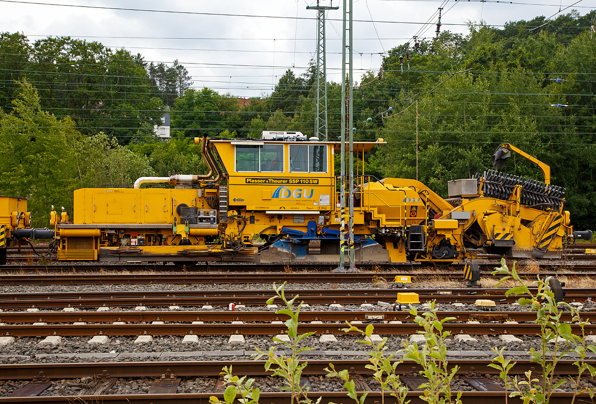 
Seitenansicht von der Plasser & Theurer Schotterverteil- und Planiermaschine SSP 110 SW (Schweres Nebenfahrzeug Nr. 97 16 46 519 18 - 3) der DGU (Deutsche Gleisbau Union), abgestellt am 24.06.2018 in Betzdorf/Sieg.

Der Schotterpflug wurde 2008 unter der Masch.-Nr. 847 von Plasser & Theurer gebaut.

Schotterpflüge werden vor oder nach dem Stopfen des Gleises eingesetzt.
Die Maschinen bewirken eine optimale Schotterverteilung und Formen das Profil des Schotterbettes. Dies ist notwendig für den Seitenwiederstand des Schotterbettes. Der Schotterpflug SSP 110 SW ist mit einem Schotterbunker von 5 m³ ausgestattet. Der Schotterpflug SSP 110 SW kann sowohl für Gleis- als auch Weichenschotterplanierarbeiten eingesetzt werden.

Technische Daten:
Eigengewicht: 44 t
Länge über Puffer: 17.220 mm 
Achsanzahl: 2 (große Räder) 
Achsabstand: 8.100 mm
Motorleistung: 400 kW
Fahrgeschwindigkeit mit Eigenantrieb: 100 km/h
Kleinster befahrbarer Radius: 120 m
zul. Streckenklasse: D4 oder höher
