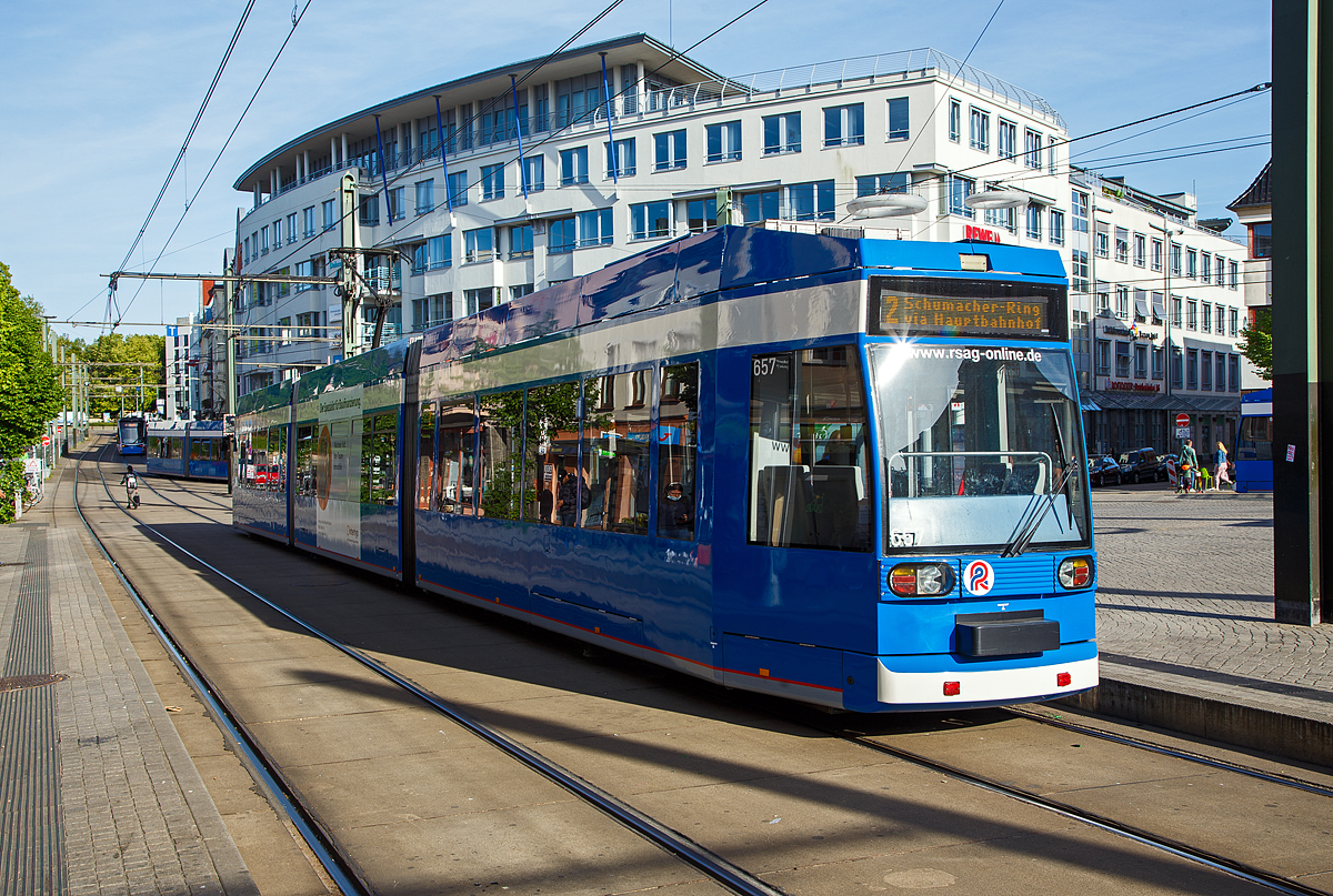 Straßenbahn Getümmel in Rostock, im Bild gleich vier Triebwagen im Bild am Doberaner Platz, hier am 14.05.2022. Im Vordergrund der Triebwagen 657 ein Niederflur-Gelenktriebwagen vom Typ DUEWAG 6N GTW DE „6N1“.

Der Niederflurgelenktriebwagen für die Rostocker Straßenbahn AG (RSAG) basiert auf dem DUEWAG MGT6D / NF6D. Als Grundlage diente die Kasseler Ausführung. Das A- und B-Teil ist etwas länger ausgeführt, was statt der Stufen im Innenraum Rampen zulässt. Lediglich die beiden einflügeligen Türen vorn und hinten weisen eine Stufe auf, zu den vier Sitzen im Heck beim Hilfsfahrschalter muss eine weitere Stufe überwunden werden. So haben die sechsachsigen Einrichtungswagen einem Niederfluranteil von etwa 90 %. Die Gelenktriebwagen sind lediglich mit einschiebbaren Notkupplungen ausgerüstet, da die Fahrzeuge nicht in Doppeltraktion eingesetzt werden. 40 Wagen dieses Typs wurden, von 1994 bis 1996, beschafft, sie tragen die Wagennummern 651 bis 690.

Die Fahrzeuge sind mit Klimaanlage im Fahrerraum ausgestattet. Seit Mitte 2005 erhalten die Fahrzeuge eine Grundsanierung die sowohl den Innenraum als auch äußerliche Merkmale betreffen. Mit der Inbetriebnahme der zweiten Generation von Niederflur-Gelenktriebwagen erfolgte eine interne Umbennenung des Fahrzeugtyps in 6N1. Die ursprüngliche Bezeichnung lautete hier 6NGTWDE. Am 17. Mai 2021 erfolgte die Ausschreibung zur Modernisierung von 10 Triebwagen dieses Typs. Eventuell sollen insgesamt bis zu 15 Fahrzeuge modernisiert werden um bis zum Jahr 2036 im Einsatz stehen zu können

Die Fahrzeuge wurden wagenbaulich/mechanisch von DUEWAG bzw. DWA Waggonbau Bautzen hergestellt und elektrisch von ABB Daimler-Benz Transportation (Stromrichter und Fahrmotoren) sowie Siemens (Steuerung und sonstige elektrische Ausrüstung) ausgerüstet. Die Mittelteile laufen auf zwei Einzelrad-Einachsfahrwerken (EEF), die darauf aufgesattelten Endteile außerdem auf je einem Triebdrehgestell mit zwei wassergekühlten Drehstrommotoren mit einer Leistung von jeweils 95 kW. Ein Wagen ist 30,4 m lang, 2,3 m breit und 3,38 m hoch (über Blech) und hat drei zweiflügelige und zwei einflügelige Schwenkschiebetüren, letztere an den Wagenenden.

TECHNISCHE DATEN der N61 der RSAG:
Hersteller Wagenbaulicher Teil: DUEWAG / DWA Bautzen
Hersteller Elektrischer Teil: ABB/Siemens
Bauart: Einrichtungswagen, 3teilig
Spurweite: 1.435 mm (Normalspur)
Anzahl Achsen: 6 (2 Drehgestelle und 2 Einzelrad-Einachsfahrwerke)
Achsfolge: Bo'+1'1'+Bo'
Länge: 30.100 mm
Breite: 2.380 mm
Höhe: 3.377 mm
Achsabstand in den Drehgestellen: 1.800 mm
Leergewicht: 30.400 kg
Sitzplätze: 91
Stehplätze bei 4 Pers./m): 92
Motorleistung: 4 x 95 kW
Nennspannung: 750 Volt DC Oberleitung
Höchstgeschwindigkeit: 70 km/h
Niederflurbereich: 90 %
Fußbodenhöhe: 350 bis 560 mm
Anzahl der Türen: 3 Doppeltüren und 2 Einzeltüren

Die Straßenbahn Rostock ist neben der Straßenbahn in Schwerin die einzige noch bestehende in Mecklenburg-Vorpommern. Das Netz umfasst eine Streckenlänge von 35,6 Kilometer und 64 Haltestellen. Die erste Pferdebahn fuhr 1881 in der Innenstadt, die weiterhin das Zentrum des Netzes darstellt. Bis 2006 wurde das Netz nach und nach erweitert, sodass der Busverkehr nur noch die Hälfte des Verkehrsbedarfes abdecken muss. Seit 1992 kommen auch Niederflur-Gelenkwagen zum Einsatz. Seit etwa 2003 kann man bei sämtlichen Fahrten barrierefrei einsteigen.
