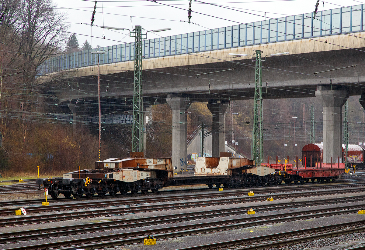 
Tiefladewagen mit 16 Radsätzen 35 80 9957 000-6 D-NCS der Gattung Uaais 823 der DAHER PROJECTS GmbH (ex NCS - NUCLEAR CARGO + SERVICE GmbH, Hanau, abgestellt am 10.02.2019 in Kreuztal.

Bei diesem Fahrzeug handelt es sich um einen sechzehnachsigen Schienentiefladewagen mit Sondereinrichtungen und gekröpfter Ladebrücke. Der Wagen wurde 1989 bei Krupp gebaut und an die Deutsche Bundesbahn geliefert. Die NCS (NUCLEAR CARGO + SERVICE GmbH in Hanau) gehörte bis Dezember 2006 zur DB Schenker und wurde an das französische Unternehmen DAHER S.A. verkauft.

Verwendungszweck des Wagens ist der Transport schwerer und voluminöser Güter, wie Walzen, schwere Schiffsdiesel, Trafos und Behälter.

Technische Daten:
Spurweite: 1.435 mm (Normalspur)
Anzahl der Achsen: 16 in 4 Drehgestellen
Gattungszeichen/Bauartnummer: Uaai 823
Ladelänge (gekröpft): 9.500 mm
Gesamtladelänge: 15.200 mm
Breite der Ladefläche: 2.700 mm
Länge über Puffer: 37.080 mm
Gesamthöhe: 2.412 mm
Höhe der Ladefläche über SOK: 1.065 mm
Drehzapfenabstand:  23.500 mm
Abstand der Innenführung: 18.260 mm
Achsabstände in den Drehgestellen: 1.500 mm
Laufraddurchmesser: 900 mm
Eigengewicht: 102,2 t
Eigengewicht der Ladebrücke: 46,4:
Kleinster befahrbarer Gleisbogenhalbmesser: 80 m
Höchstgeschwindigkeit: 100 km/h
Bauart der Handbremse: bodenbedienbare Handbremse
Höchstzulässiger Knickwinkel: 1°
Lastgrenzen auf Streckenklasse CM4: 108,5 t
Maximale Tagfähigkeit: 230 t
Verwendungsfähigkeit: RIV