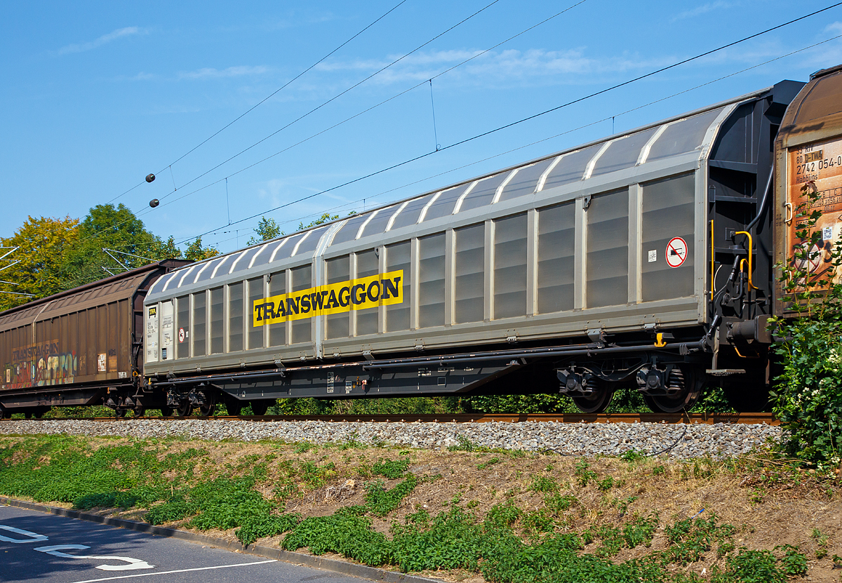 Transwaggon vierachsiger, grorumiger Drehgestell-Schiebewandwagen der Gattung Habbiins 17, 33 85 2740 809-4 CH-TWA, Gattung Habbiins 17, am 28.08.2018 im Zugverband bei Zugdurchfahrt in Bad Honnef.

Diese grorumigen Wagen sind mit Schiebewnden ausgerstet, die von einer Person bewegt werden knnen. Im geffneten Zustand ist der Zugang zur halben Ladeflche von beiden Seiten mglich. Das Be- und Entladen mit Gabelstaplern ist damit sowohl von einer Rampe als auch von ebener Erde mglich. Die Wagen sind fr eine schonende Befrderung hochempfindlicher Gter verschiedener Art. Er bietet Platz fr 63 Euro-Paletten (800 x 1.200 mm) oder 42 Industrie-Paletten (1.000 x 1.200 mm).

TECHNISCHE DATEN:
Spurweite: 1.435 mm
Anzahl der Achsen: 4 (in zwei Drehgestellen)
Lnge ber Puffer: 23.264 mm
Drehzapfenabstand: 17.724 mm
Achsabstand im Drehgestell: 1.800 mm
Ladelnge: 22.000 mm
Ladebreit: 2.840 mm
Ladeflche: 62,4 m
Laderaum: 167 m
Fubodenhhe von SOK:  1.200 mm
Min. befahrbarer Kurvenradius:  R= 60 m
Eigengewicht: 26.000 kg
Max. Ladegewicht: 64,0 t (ab Streckenklasse D)
Maximale Radsatzlast: 22,5 t
Schiebewandffnung: 2 x 10.808 mm
Hchstgeschwindigkeit: 100 km/h (beladen) / 120 Km/h (leer)
Bauart der Bremse: KE-GP-A max. 59 t
Verwendungsfhigkeit: RIV
