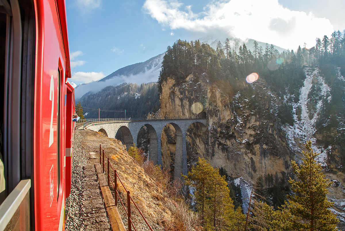 
UNESCO-Weltkulturerbe Albulabahn: Wir fahren am 18.02.2017 mit dem RE (Chur -  St. Moritz) der Rhätischen Bahn (RhB), und erreichen nun den berühmten, 136 m langen und 65 m hohen, Landwasserviadukt bei Filisur, danach geht es direkt in den 216 m langen Landwassertunnel.