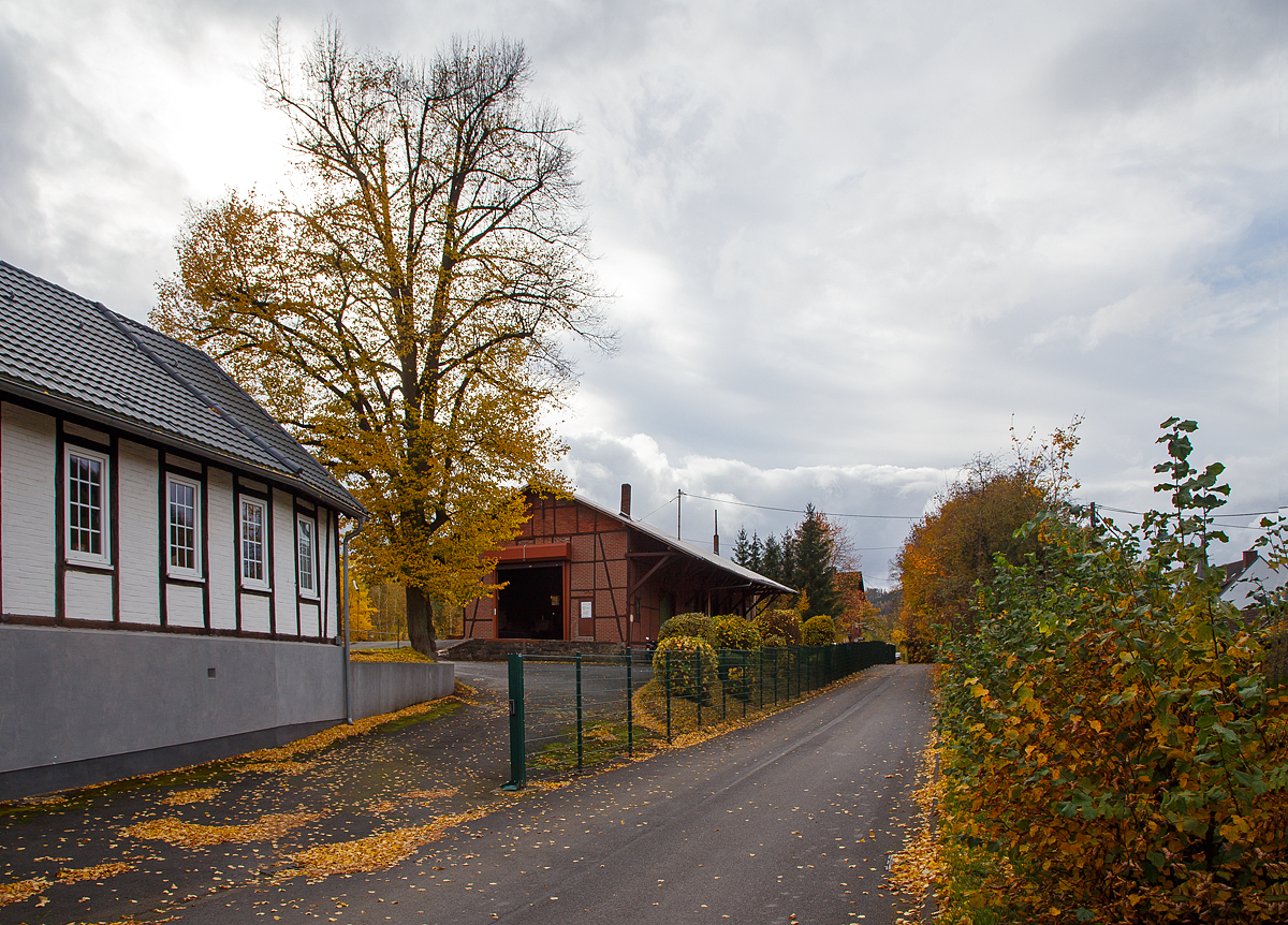 Von der Zugangsstraßenseite der Bereich vom Bahnhof Herdorf am 27.10.2020, in der Bildmitte der ehemalige Güterschuppen und hinten rechts kann man gerade noch den Giebel vom Empfangsgebäude sehen.