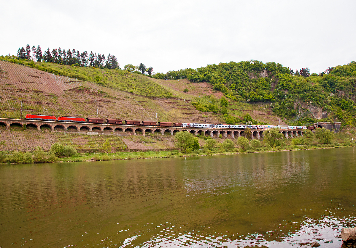 
Whrend die 189 035-9 und 189 040-9 der DB Cargo Deutschland AG einen 5.500 Tonnen schweren Erzzug am 28.04.2018 auf dem Pndericher Hangviadukt in Richtung Trier, mit dem Endziel Dillinger Htte (Saar) ziehen. Fahren davor in Gegenrichtung (kurz vor der Einfahrt in den Prinzenkopftunnel) ein dreiteiliger CFL Stadler als RE 11  Benelux-Express  gekuppelt mit einem fnfteiligen SWEX Stadler als RE 1  Sdwest-Express  in Richtung Koblenz. 