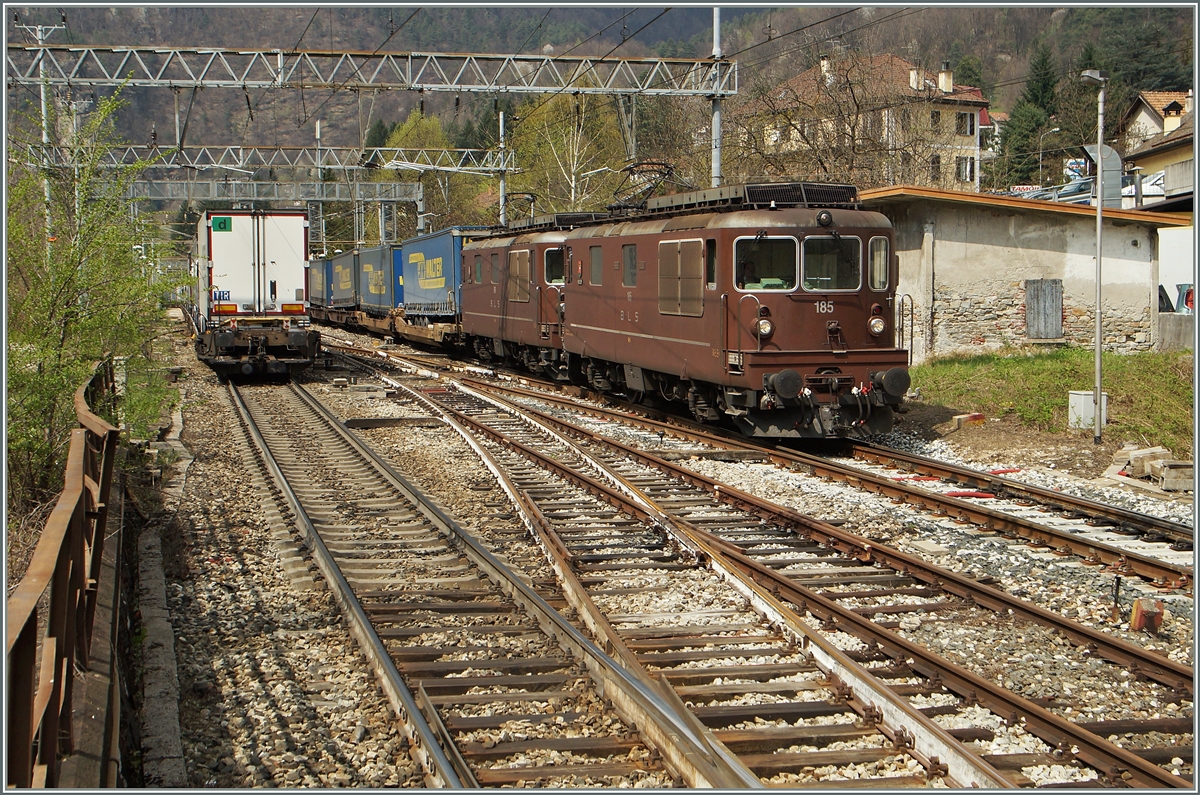 Zwei BLS Re 4/4 sind mit einem Containergüterzug bei Varzo Richtung Süden unterwegs, während ein RoLa Zug auf  Feie Fahrt  Richtung Norden wartet.
11. April 2015