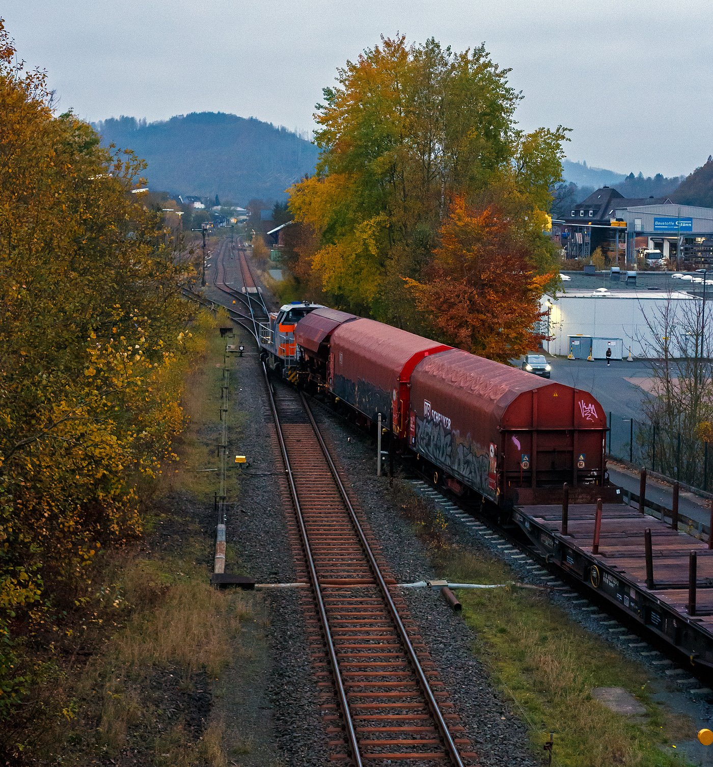 Beim letzten Licht, die KSW 47 (92 80 1271 027-5 D-KSW), ex D 2 der HFM, eine Vossloh G 1000 BB der KSW (Kreisbahn Siegen-Wittgenstein), verlässt am 08 November 2024 mit einem Übergabegüterzug (leere Wagen) den KSW-Rangierbahnhof in Herdorf (Betriebsstätte FGE -Freien Grunder Eisenbahn) und fährt nach Kreuztal, via Betzdorf und Siegen, los.