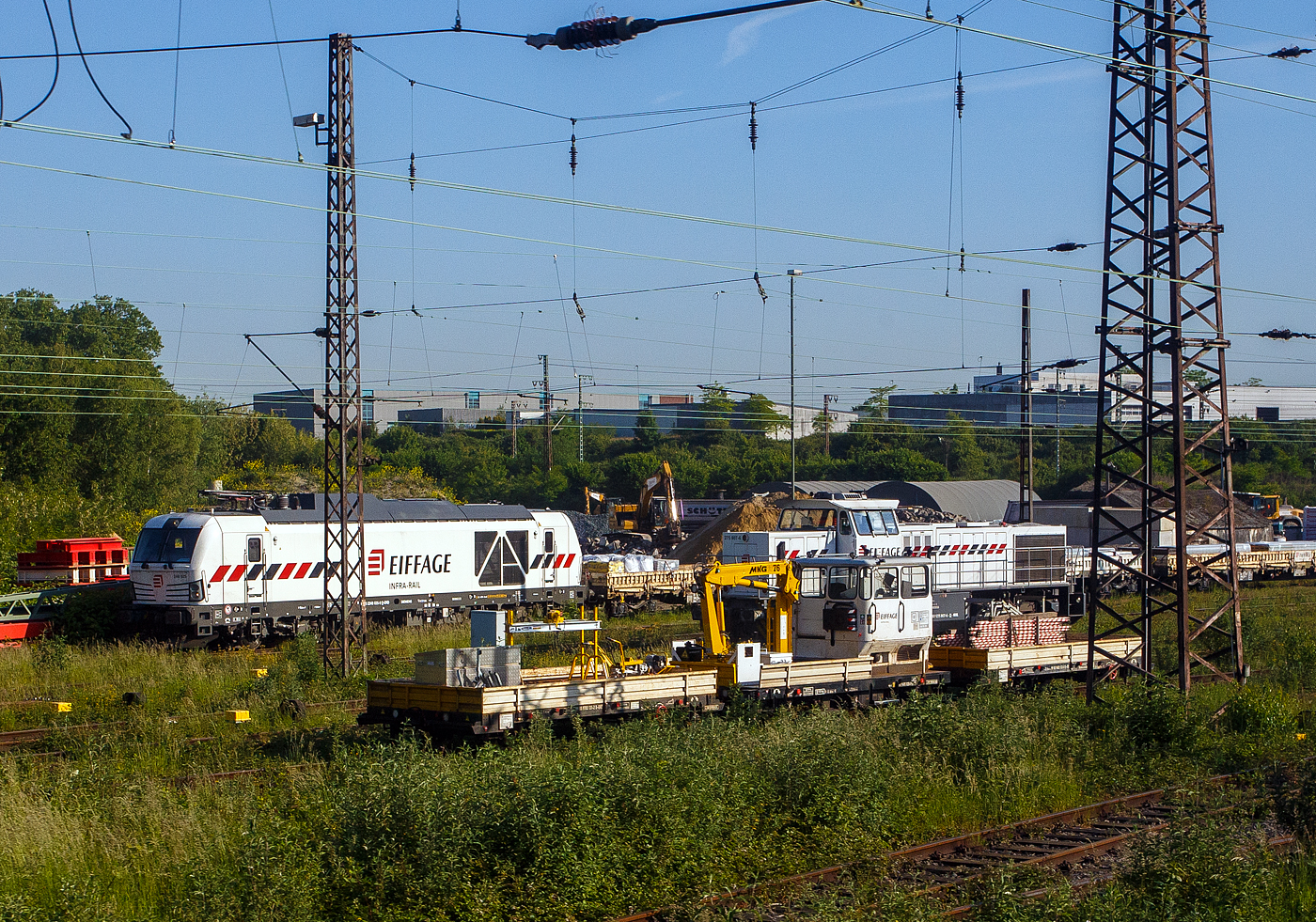 Blick am 20 Mai 2025 aus einem Zug auf den Abstellbereich (Schieneninfrastruktur) der Eiffage Infra-Rail GmbH in Herne (ehemals Heitkamp Rail GmbH): 
Vorne steht der Klv 53 mit einem neuem MKG 76 Ladekran (der MKG Maschinen- und Kranbau GmbH, Garrel), 99 80 9685 028-9 D-ERD, mit zwei Kla 03 - Anhänger für schweren Rottenkraftwagen. Hinten der Kla 03 – 99 80 9783 131-2 D-ERD und vorne der 99 80 9683 132-0 D-ERD. Die Abkürzung Klv steht für Kleinwagen mit Verbrennungsmotor. Oft wird er auch als Skl 53 bezeichnet, wobei das Skl für Schwerkleinwagen steht.

Rechts dahinter die an die Eiffage Infra-Rail vermietete 275 807-6 (92 80 1275 807-6 D-NRAIL), eine Vossloh G 1206 der der Northrail GmbH. Sie wurde 1999 von der Vossloh Locomotives GmbH in Kiel-Friedrichsort unter der Fabriknummer 1001016, als Mietlok der Vossloh, gebaut. Nach vielen Stationen ging sie 2024 an Northrail GmbH in Hamburg.

Und hinten die SIEMENS Vectron Dual Mode 248 025-9 (90 80 2248 025-9 D-ERD) der Eiffage Infra-Rail. Die SIEMENS Vectron DM wurde 2022 von Siemens Mobility GmbH in München-Allach unter der Fabriknummer 23164 gebaut und im Januar 2023 an die Eiffage Infra-Rail geliefert.

Eiffage ist ein börsennotiertes französisches Bauunternehmen mit Firmensitz in Vélizy-Villacoublay. In Deutschland hat die Eiffage Infra-Rail GmbH ihren Sitz in Herne. Im Jahre 2010 übernahm Eiffage von Heijmans den Bereich Schieneninfrastruktur der ehemaligen Firma Heitkamp. Die Gleisbaugeräte und die zugehörige Werkstatt sind auf dem Gelände der ehemaligen Heitkamp Bauholding in Herne-Wanne beheimatet.