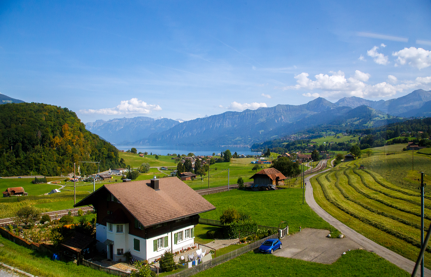 Blick aus unserem Zug auf Lötschberglinie am 08 September 2021 bei Faulensee auf die BLS-Strecke TSB - Thunerseebahn (Thun–Spiez–Interlaken Ost-BLS Werkstätte Bönigen) im Hintergrund noch der Thunersee. Hinter den Bergkette ist das Jungfraumassiv.